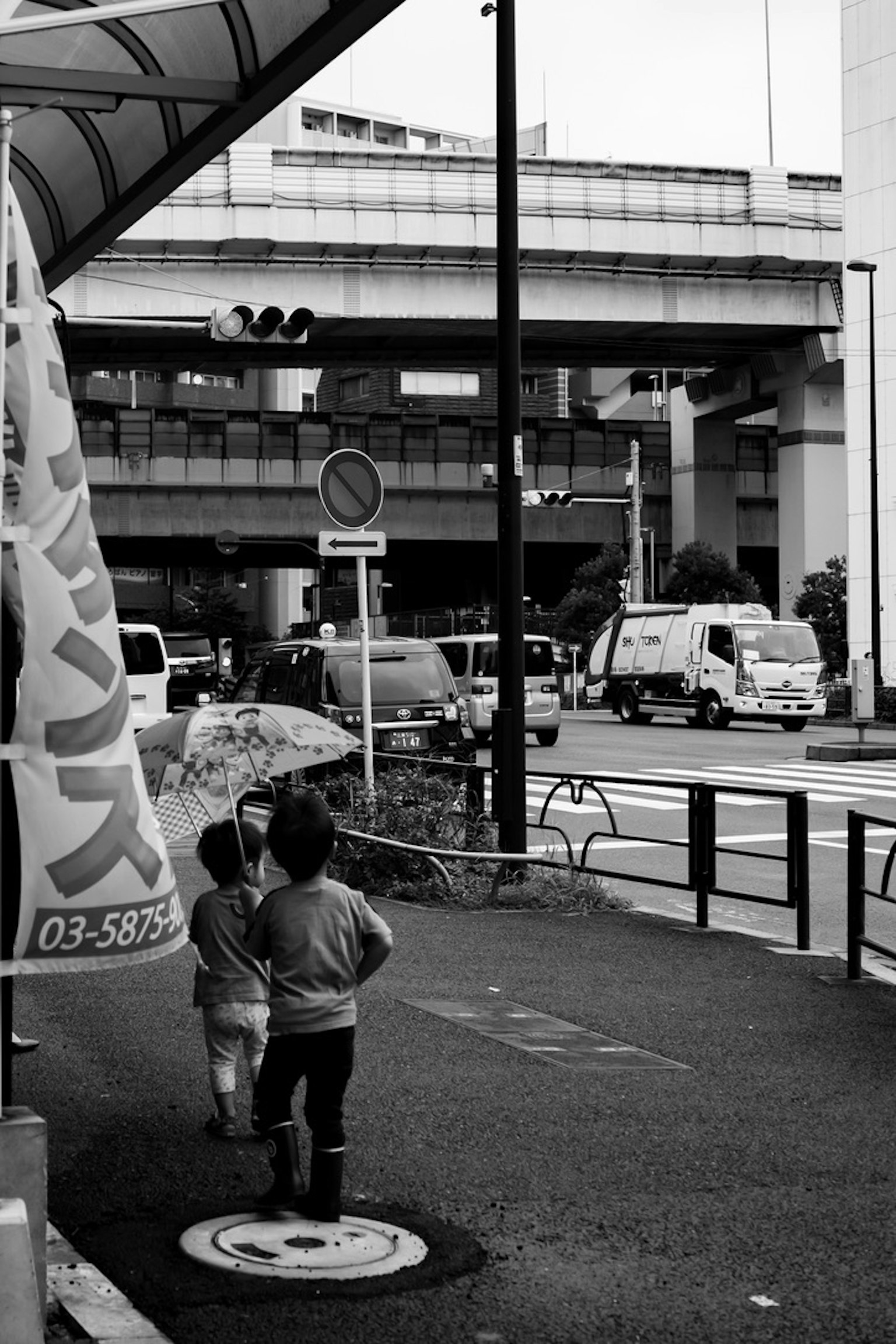 Due bambini che camminano in una strada cittadina in bianco e nero