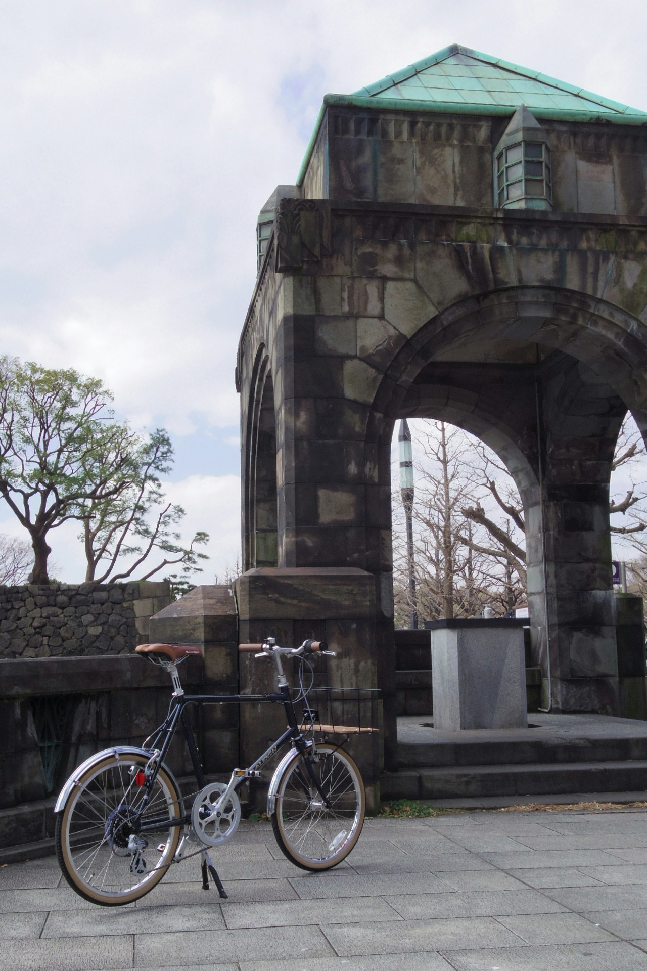 scène extérieure avec une arche en pierre et des vélos garés