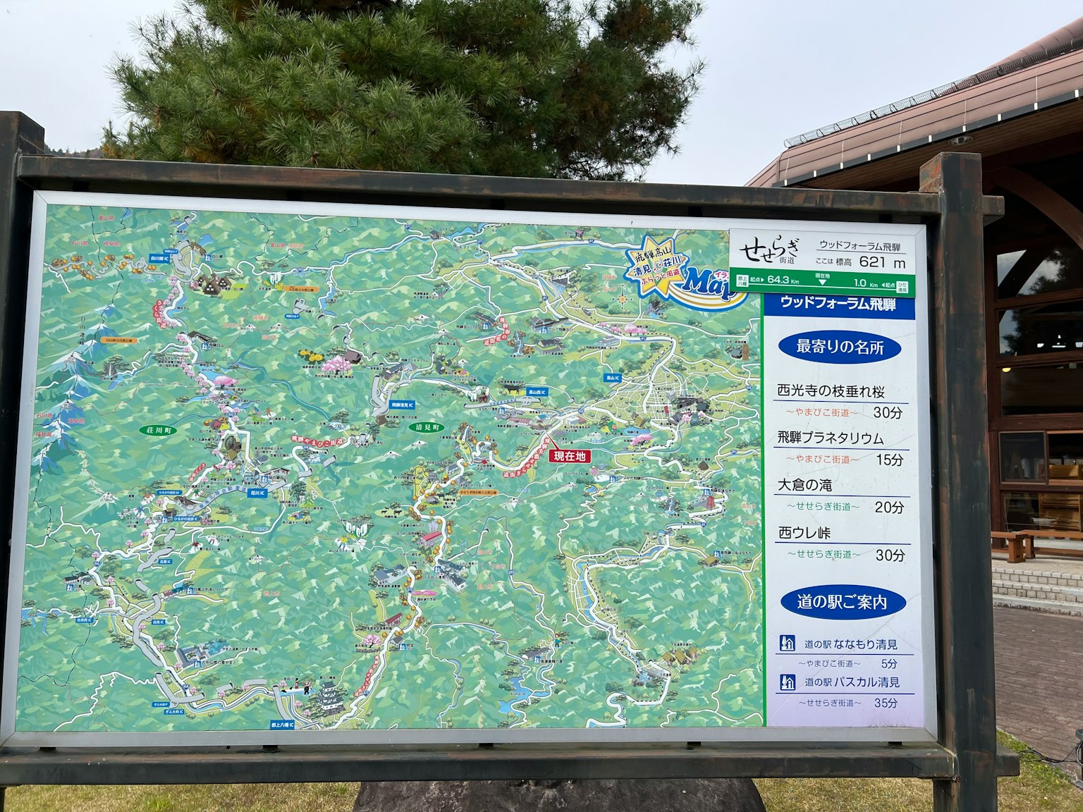Immagine di un cartello con mappa che mostra sentieri escursionistici e punti di interesse circondati da vegetazione