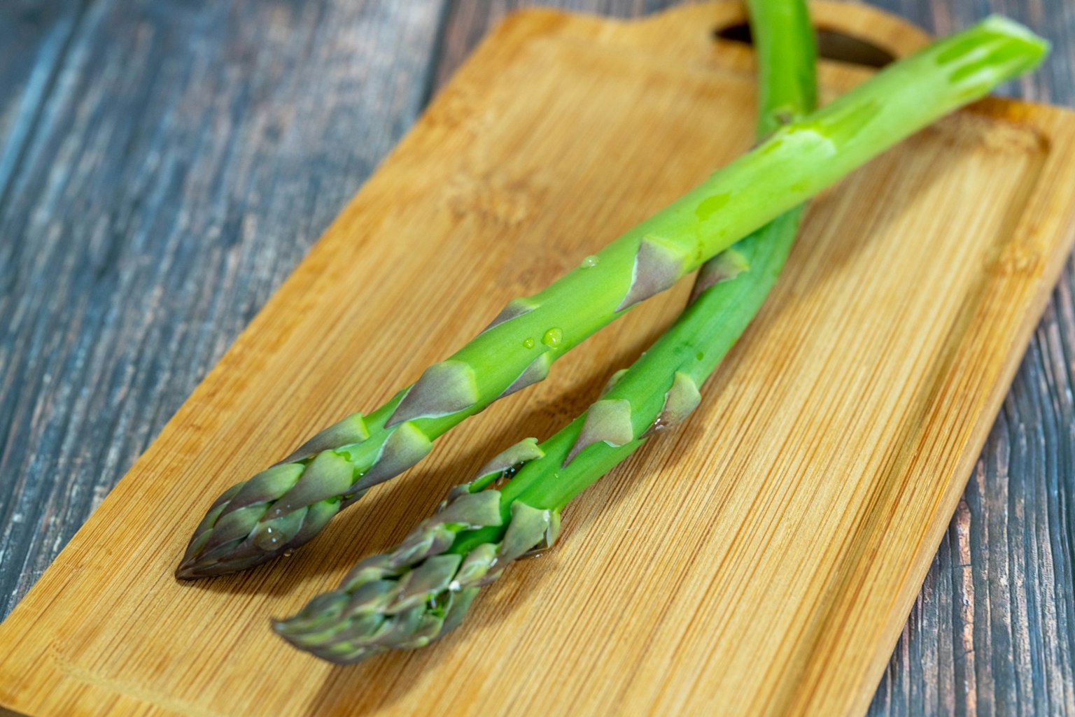 Asparagi verdi freschi su un tagliere di legno
