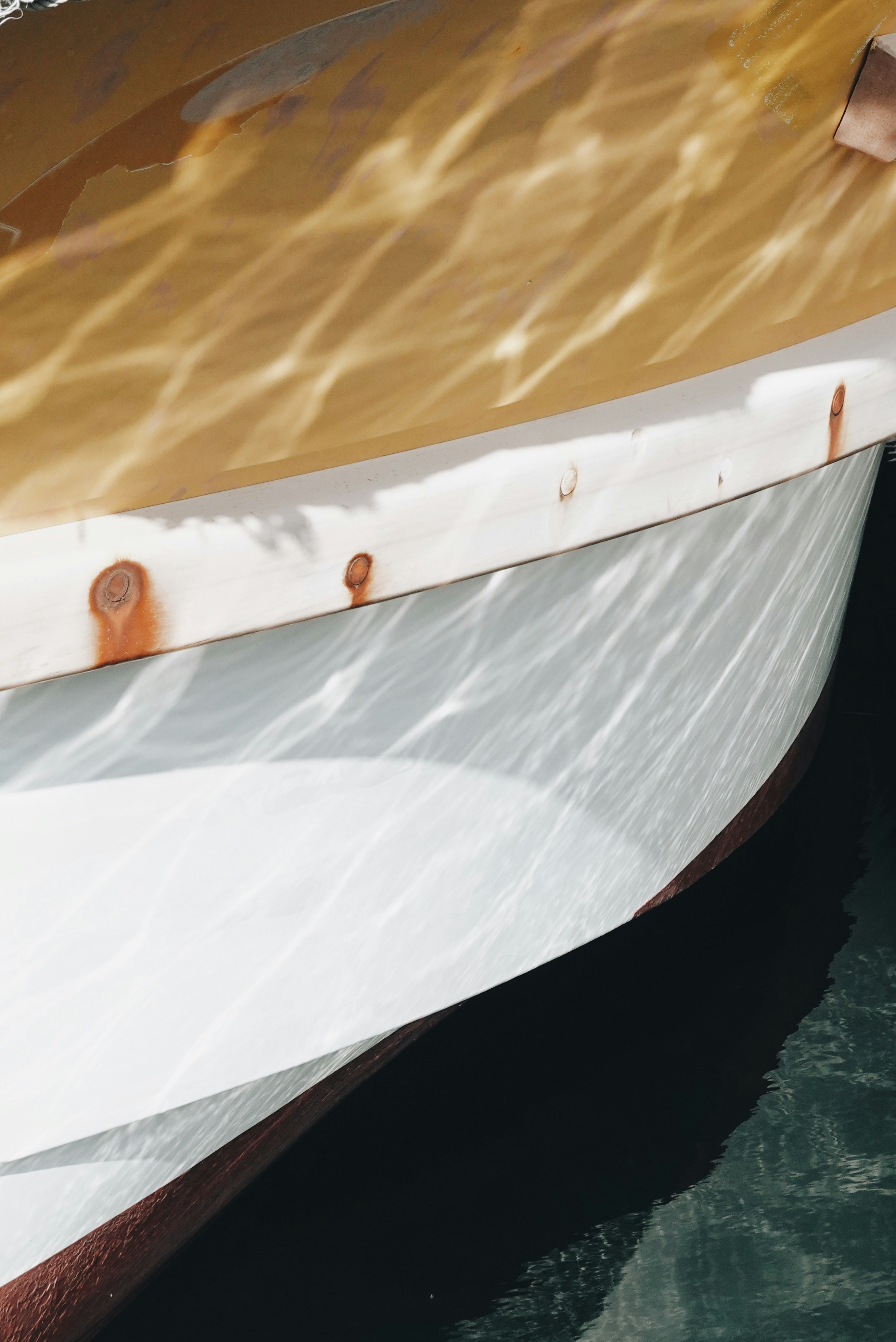 bow of a white boat cutting through rippling water