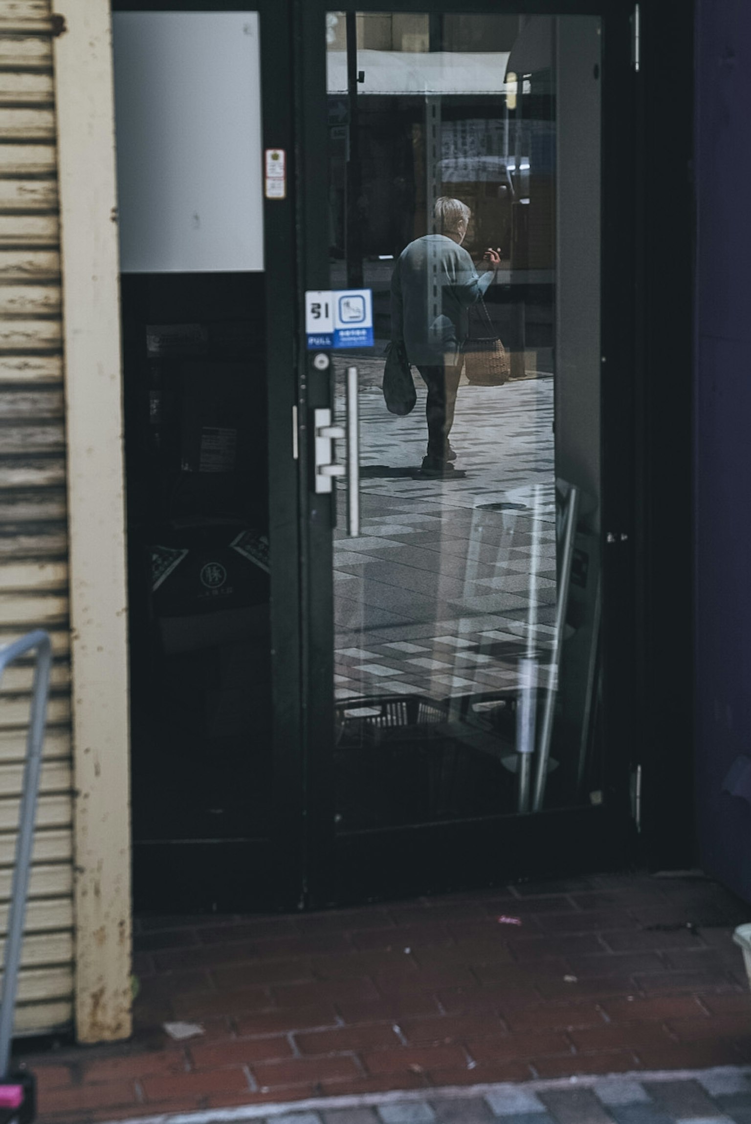 Reflection of a person and chairs in a black door