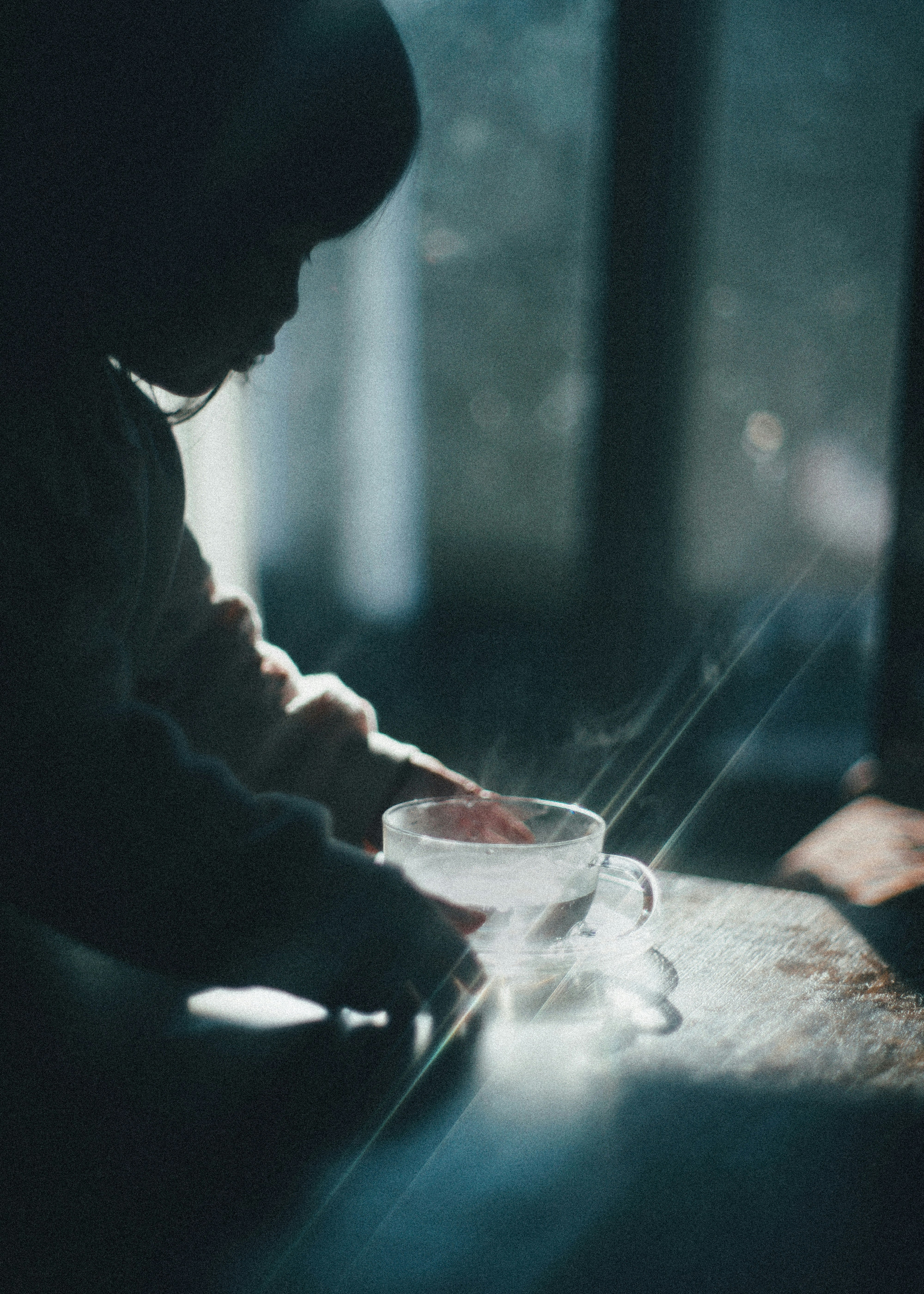 Silhouette of a child touching a steaming cup