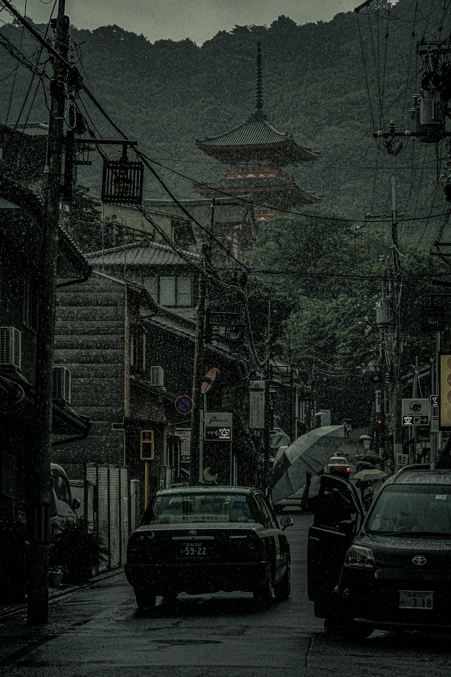 비 오는 날 산으로 둘러싸인 5층 탑이 있는 역사적인 거리 풍경