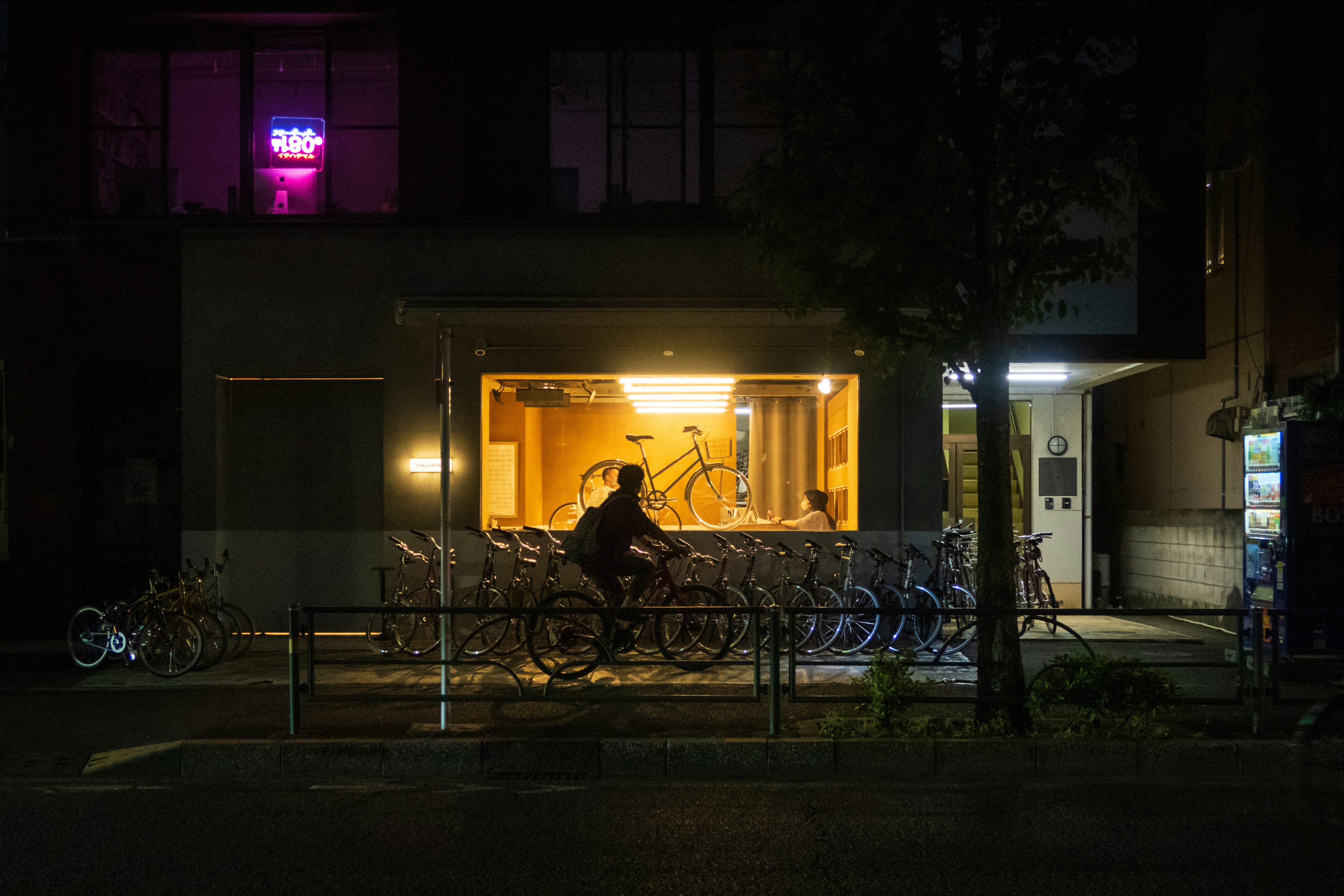 nächtliche Straßenecke mit Fahrrädern vor einer Garage