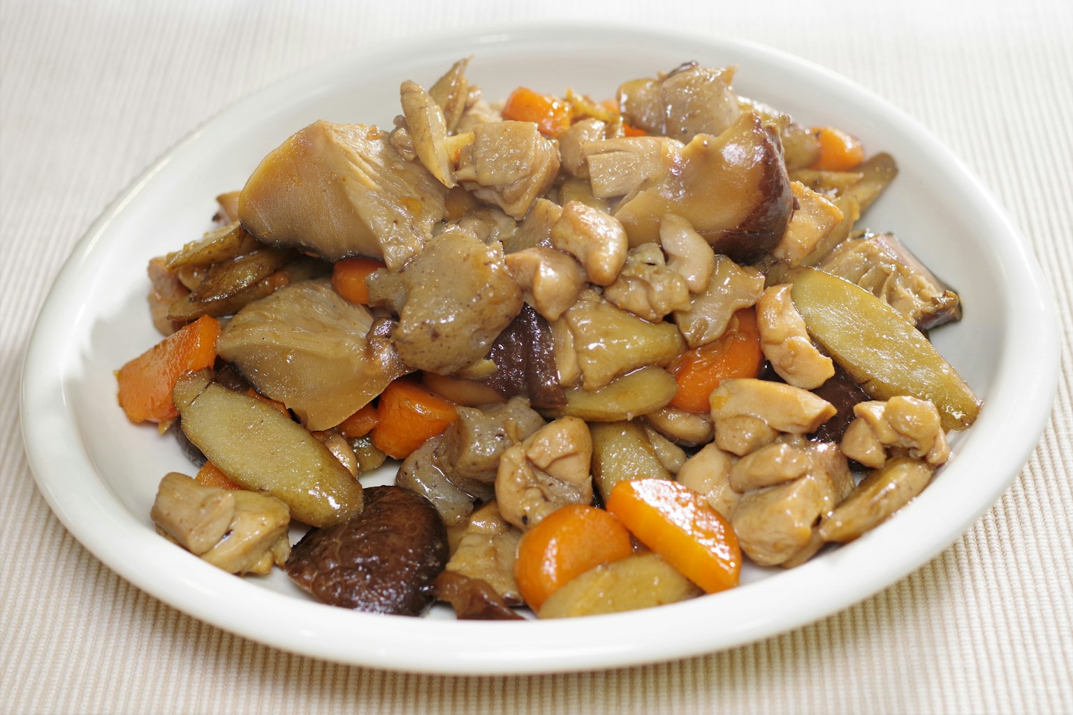 Poulet et légumes sautés servis sur une assiette blanche
