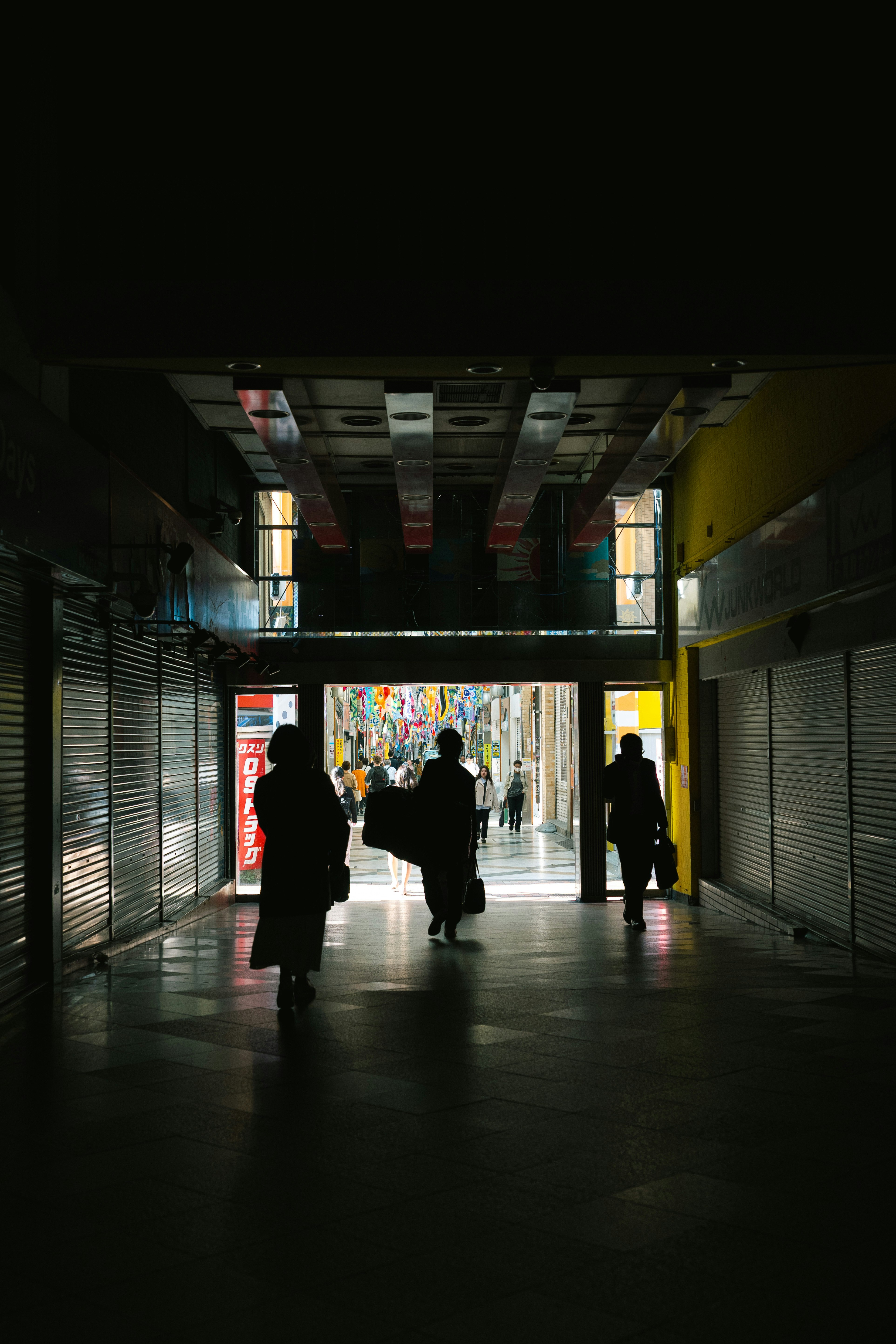 pasaje de arcade nocturno con siluetas caminando