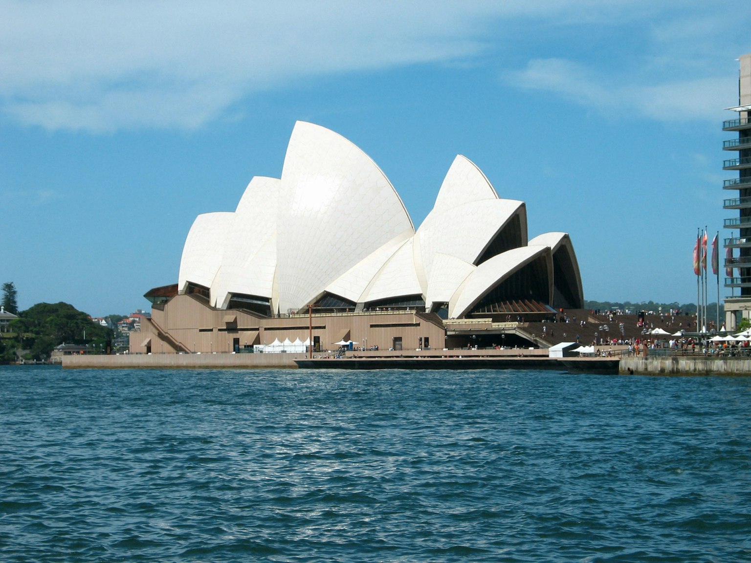 Gedung Opera Sydney dengan atap putih berbentuk layar yang ikonik dan langit biru