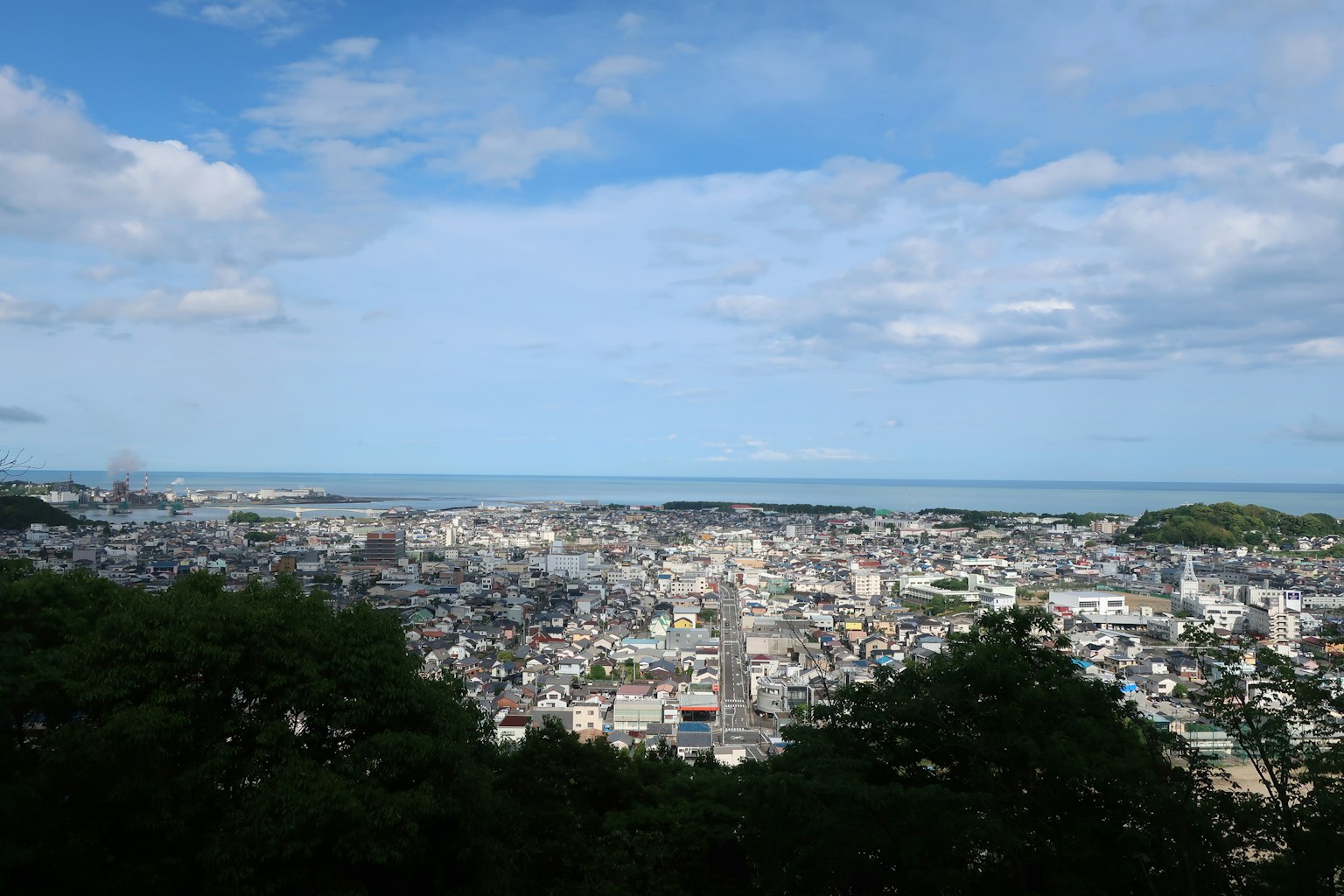 Panoramic view of a city surrounded by blue sky and sea