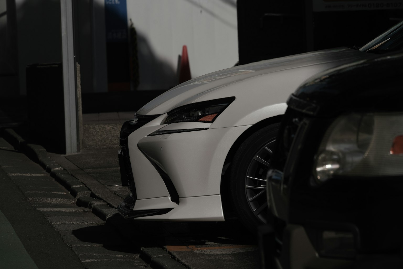 Vista frontal de un Lexus blanco estacionado en un área poco iluminada