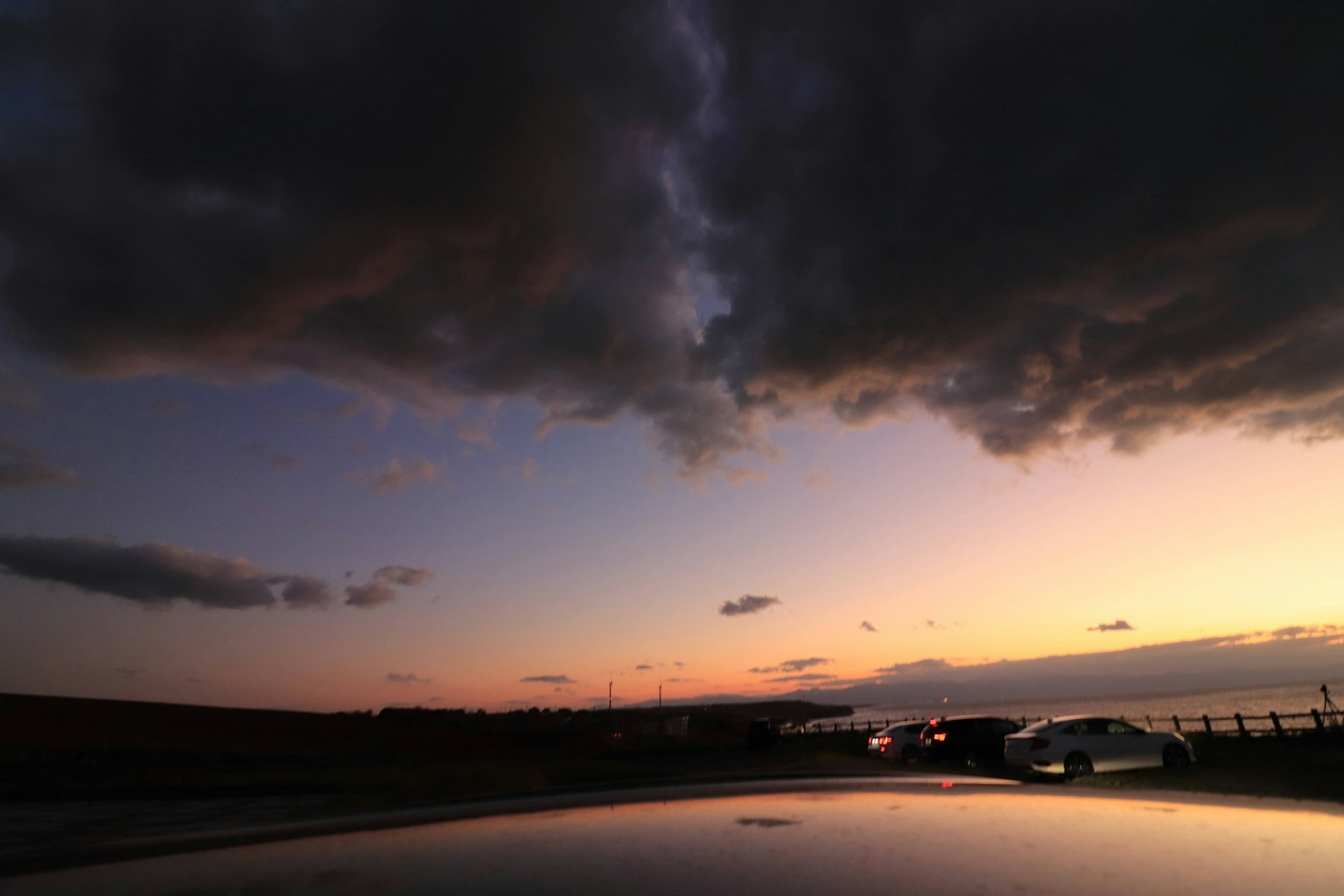 Ciel de coucher de soleil magnifique avec des nuages sombres contrastants et un horizon lointain