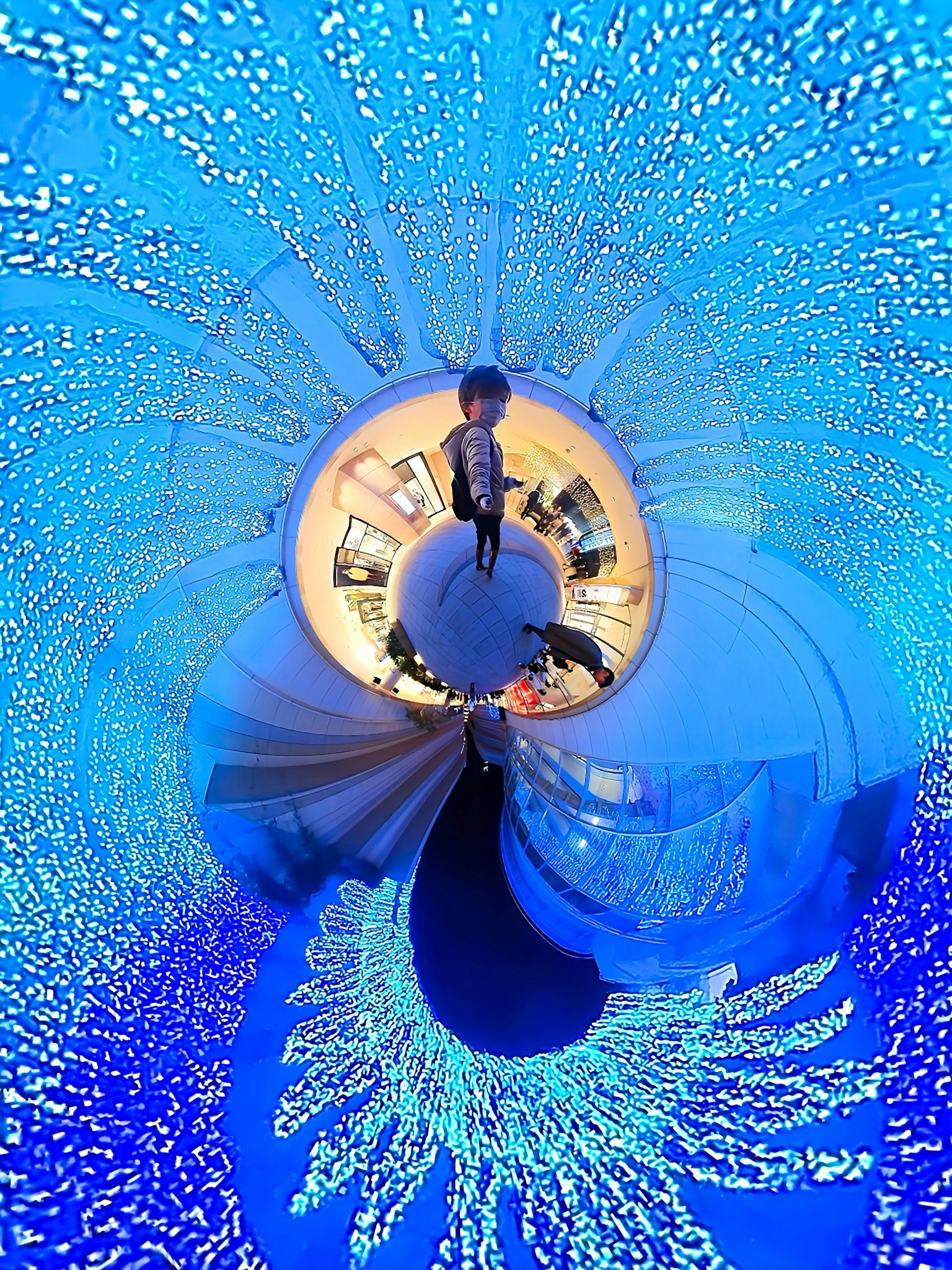บุคคลยืนอยู่ในสภาพแวดล้อมของแสงสีน้ำเงินที่หมุนวนด้วยมุมมอง 360 องศา