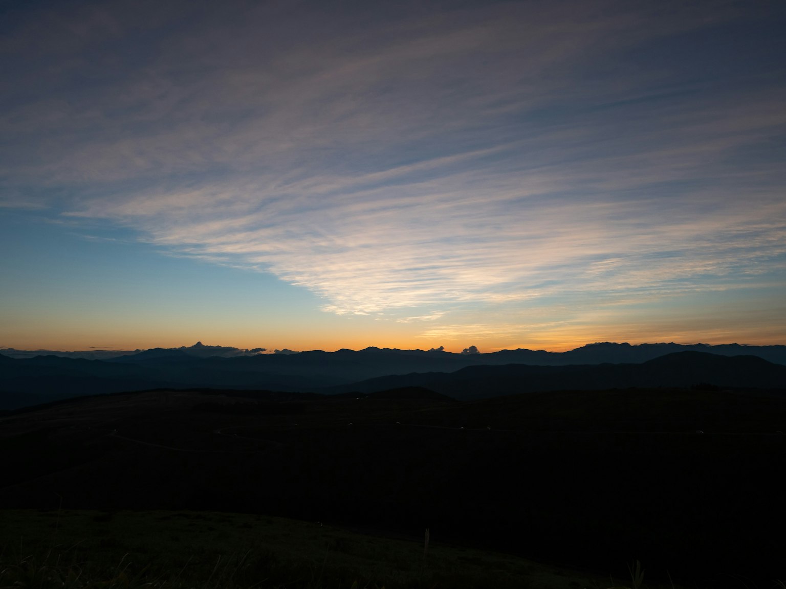 Cielo en degradado al atardecer con montañas en silueta