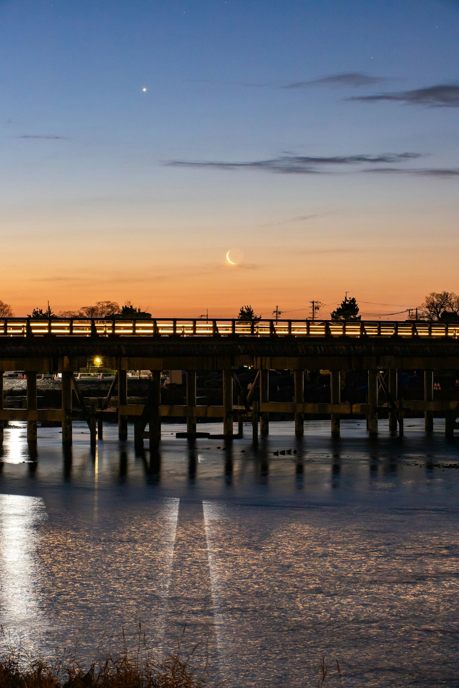 Vue pittoresque d'un pont reflétant le ciel du coucher de soleil sur l'eau