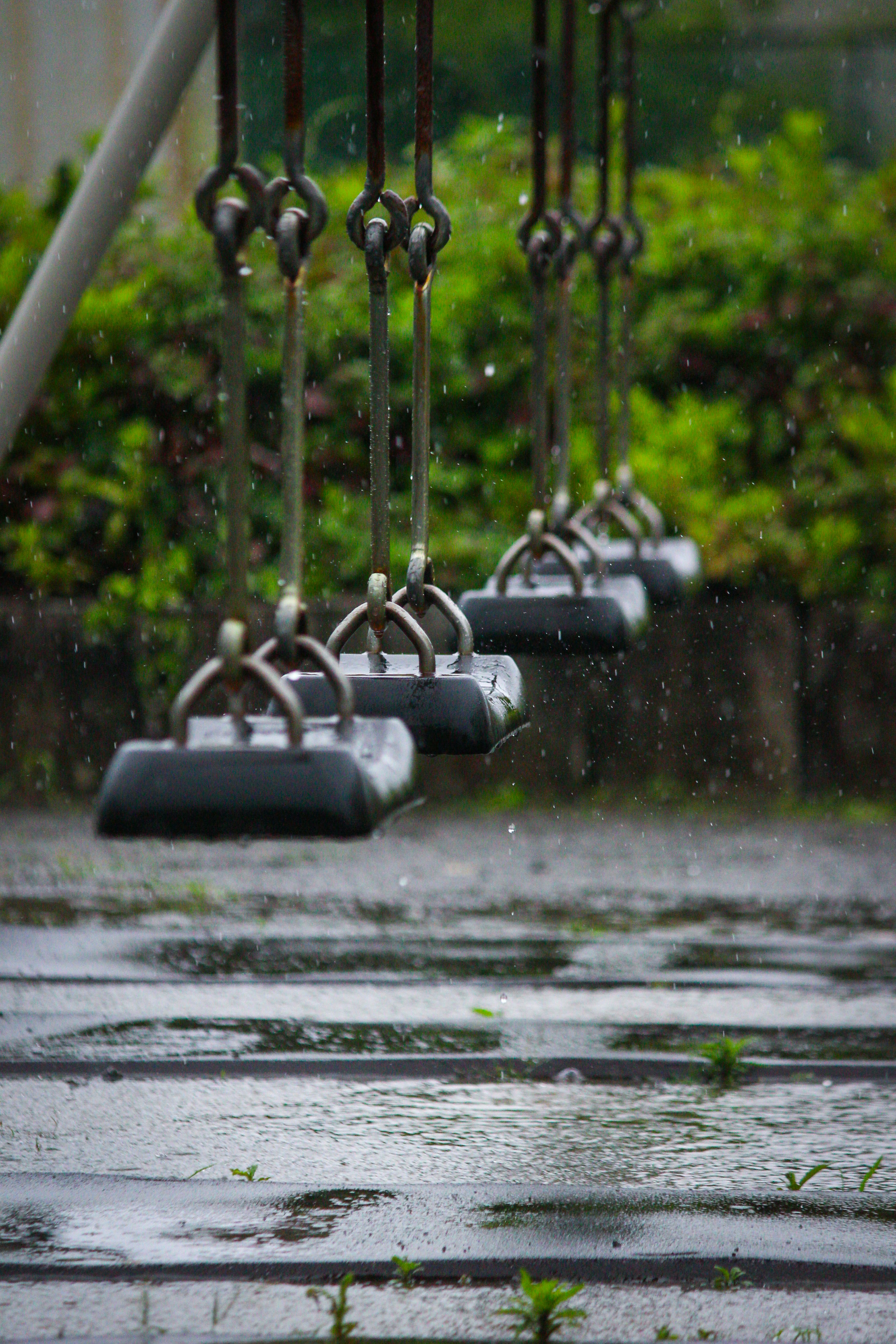 columpios de parque con lluvia intensa y superficies mojadas