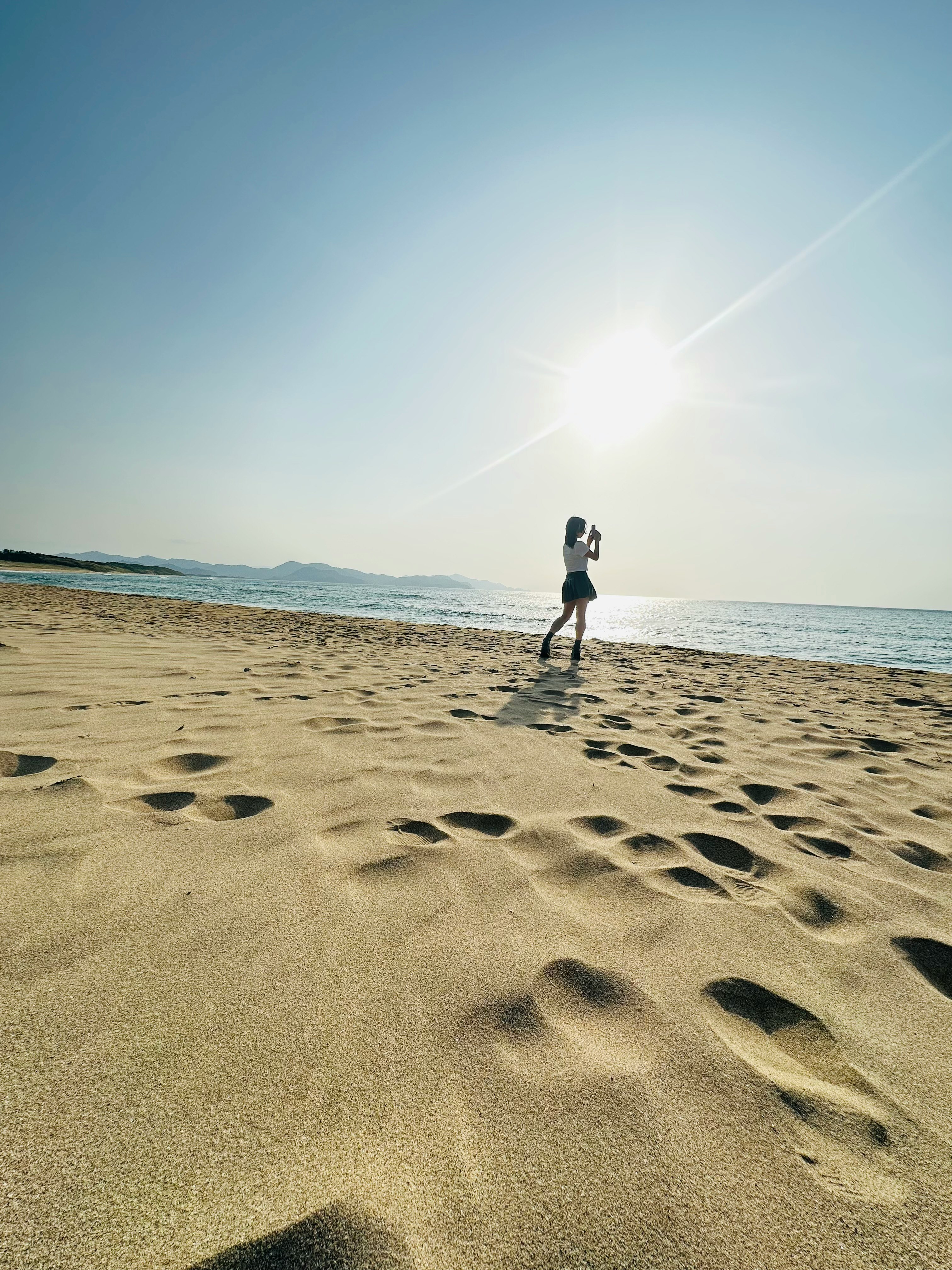 丹後半島の海岸で波打ち際を歩く人のシルエットの夕暮れの画像