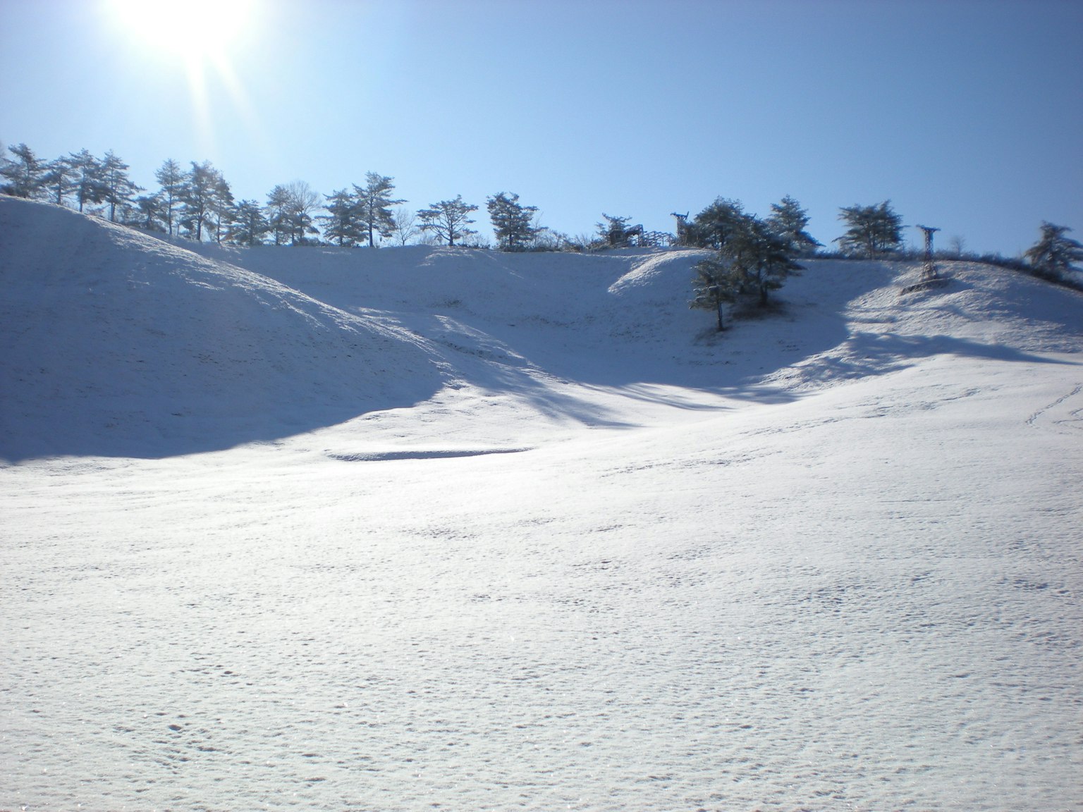 Colline innevate sotto un cielo blu chiaro