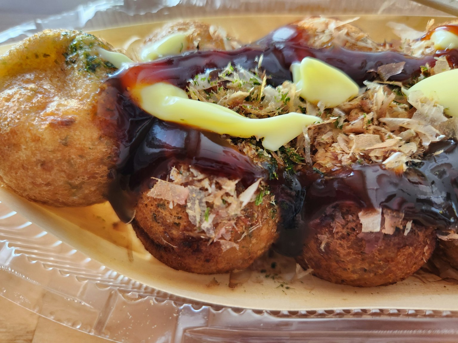 Piatto di takoyaki guarnito con salsa e maionese