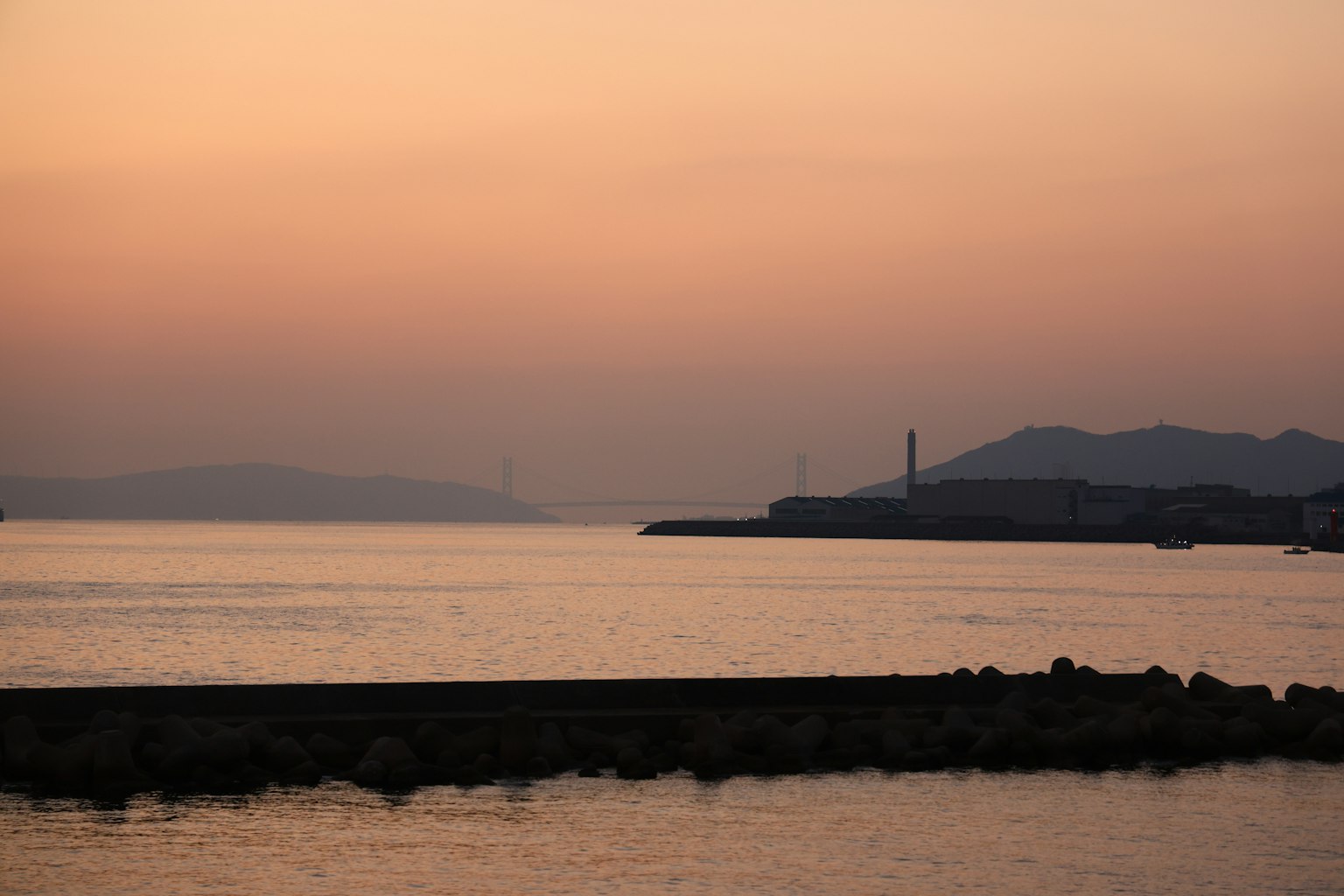 Scenic view of a coastline at sunset with calm waters