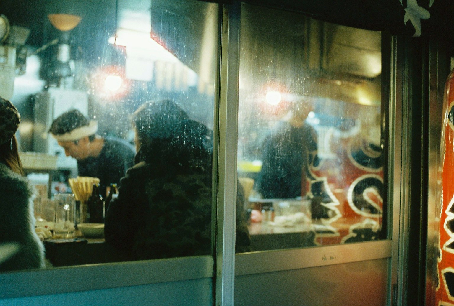 Nhìn qua kính mờ của nội thất nhà hàng với các đầu bếp đang nấu ăn