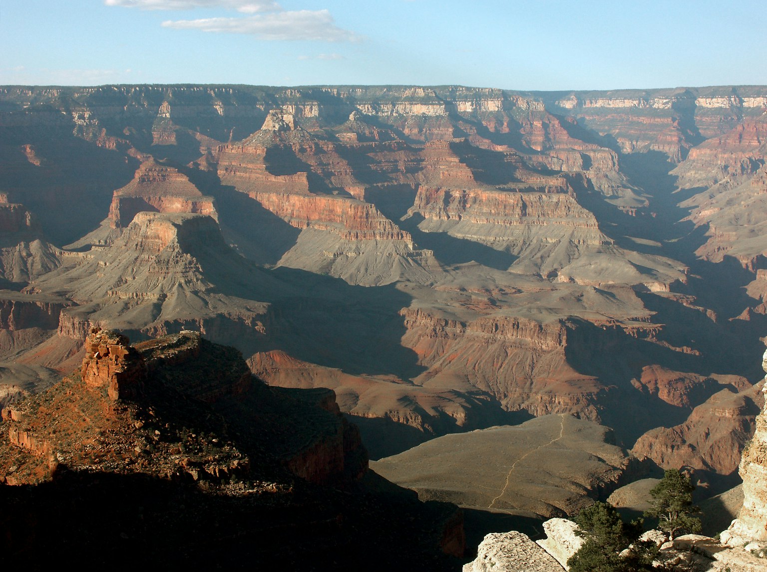 Vista maestosa del Grand Canyon con formazioni rocciose rossastre e profonde ombre