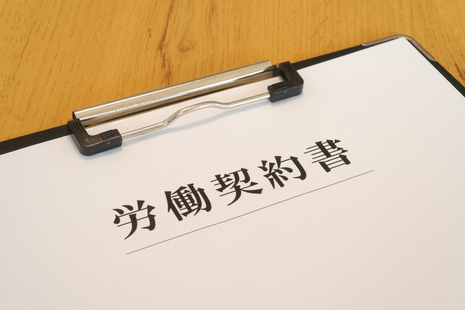 Hình ảnh của một clipboard với hợp đồng lao động được viết trên đó