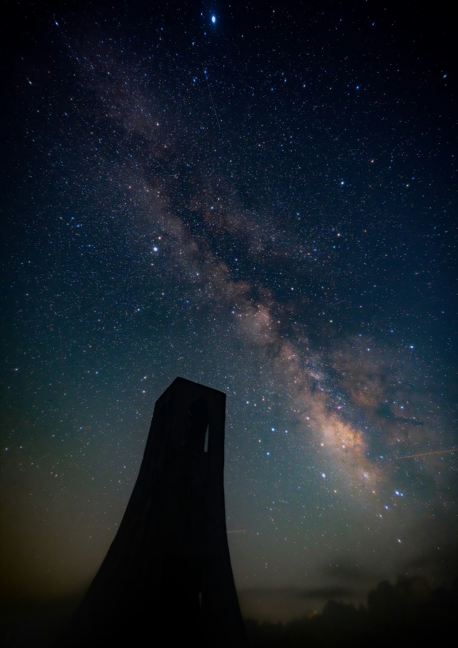 星空下的塔的輪廓與銀河