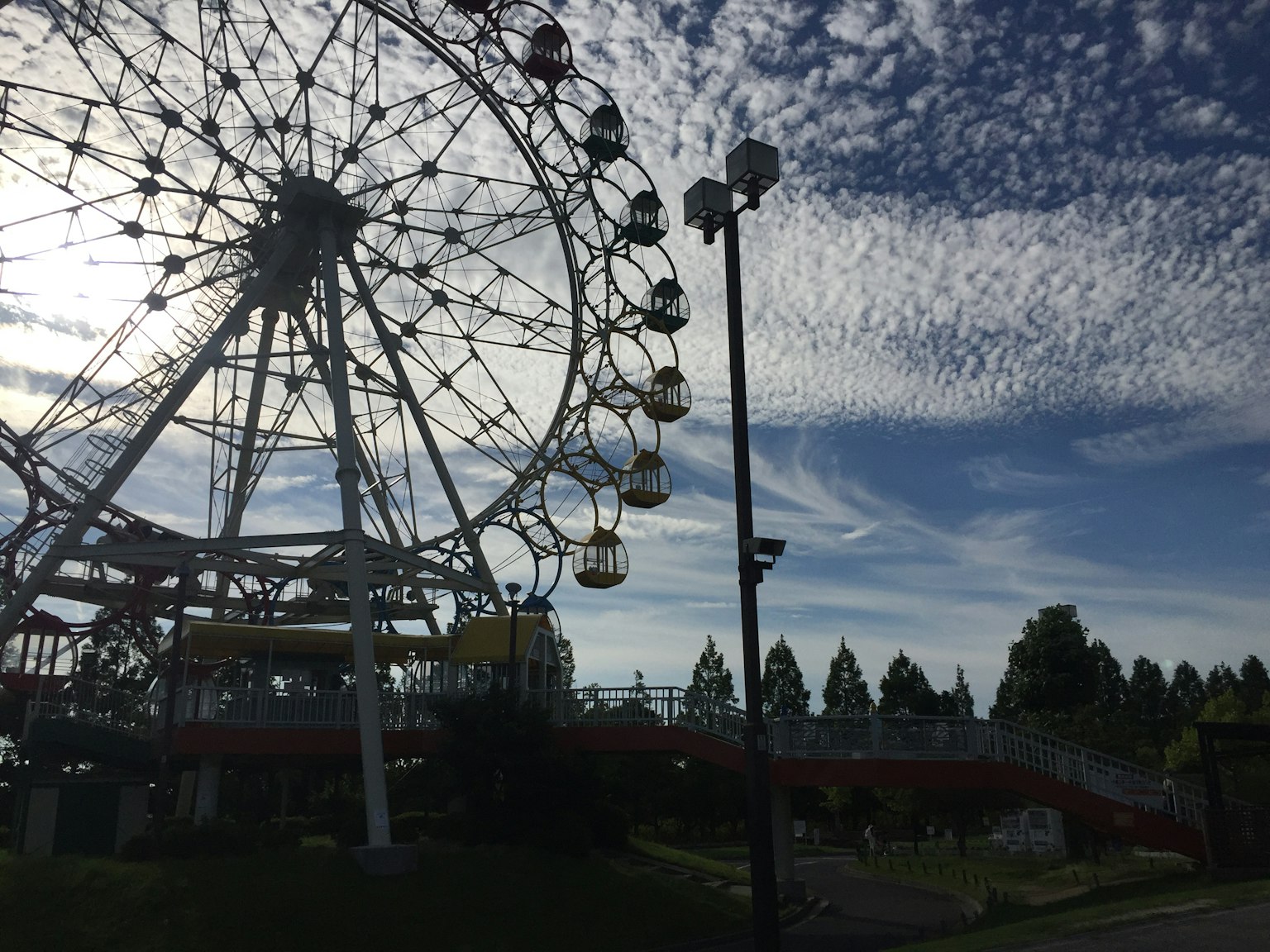Rueda de la fortuna contra un cielo azul con nubes dispersas