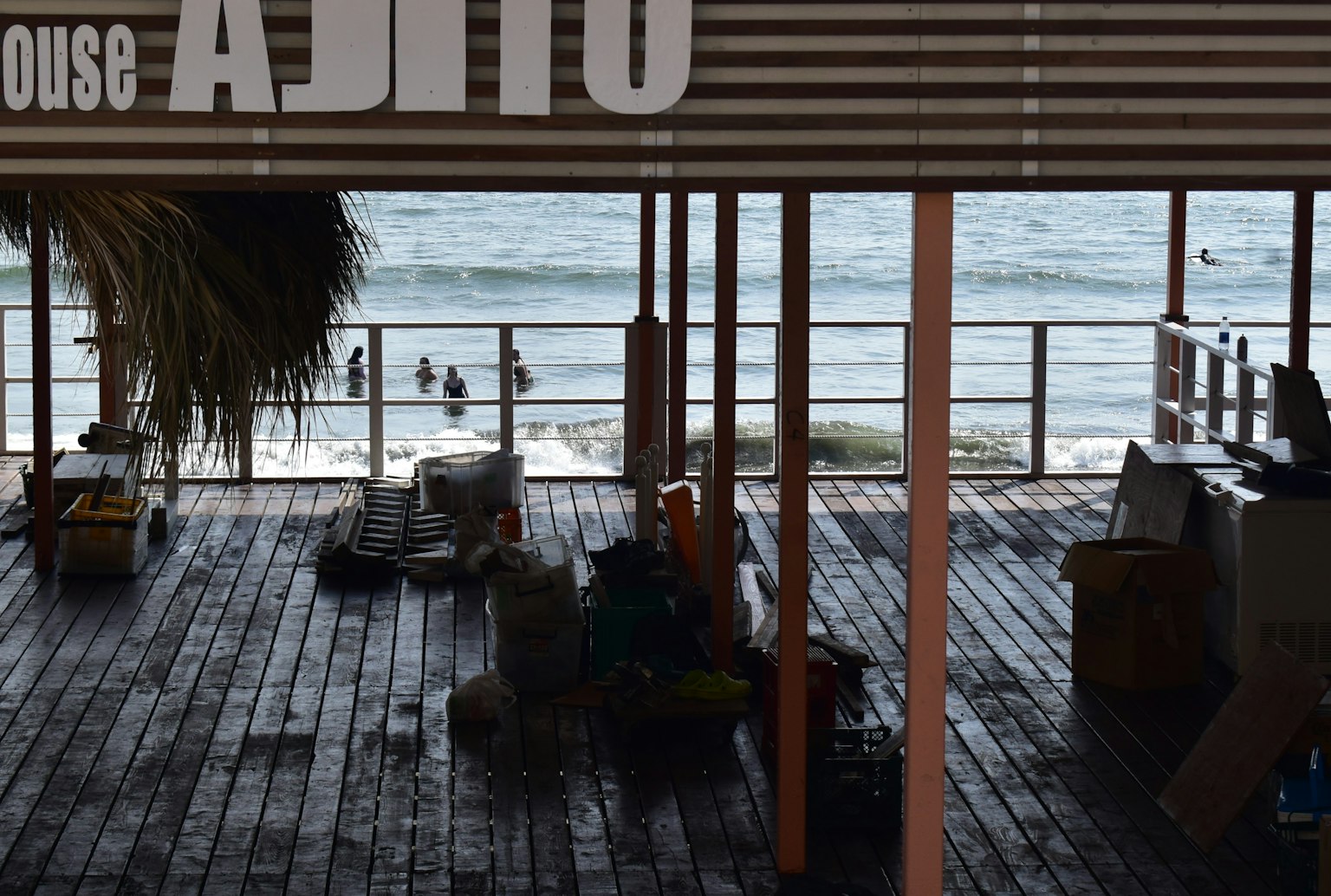 Terrazza in legno con vista sull'oceano e insegna Ajito