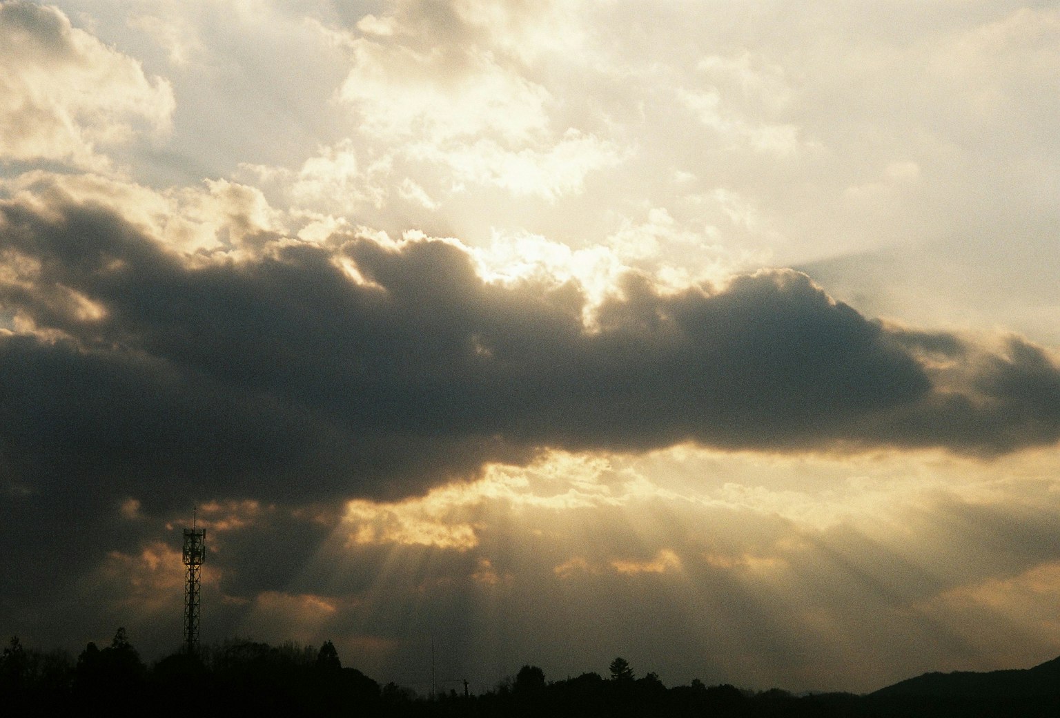 Cielo hermoso con rayos de luz brillando a través de las nubes