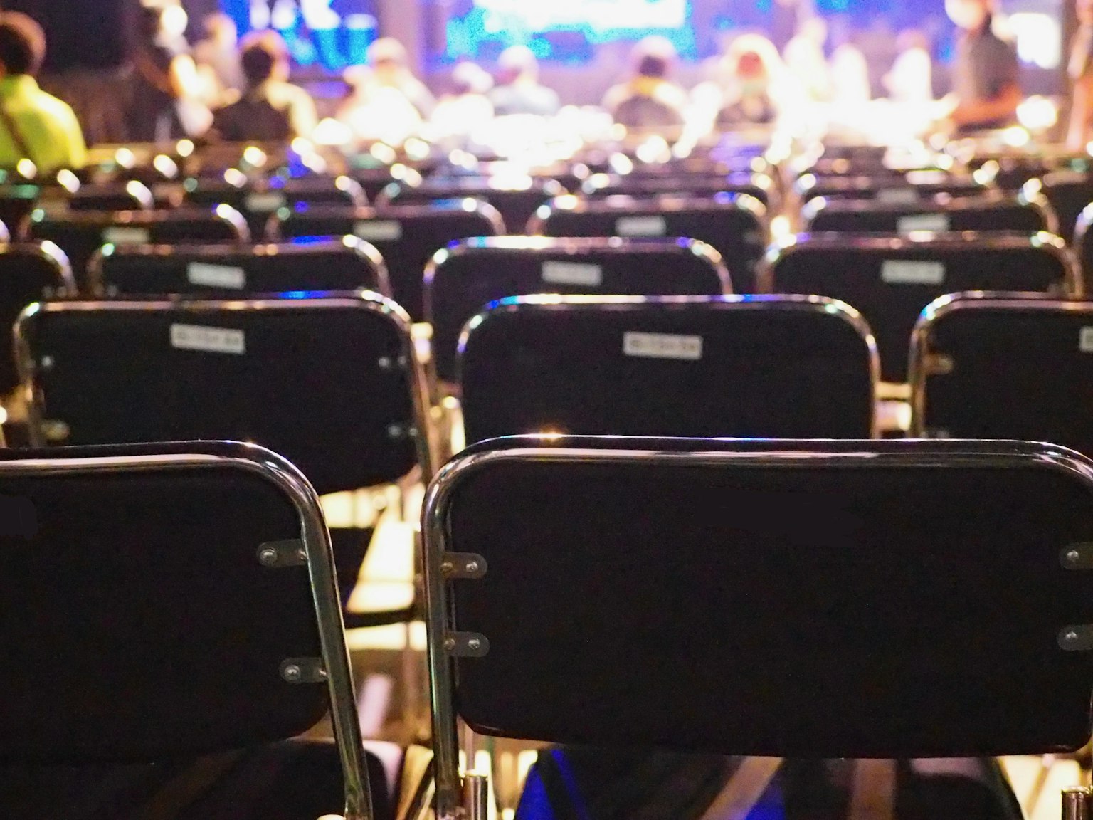 Vue de chaises pliantes noires disposées dans un lieu d'événement