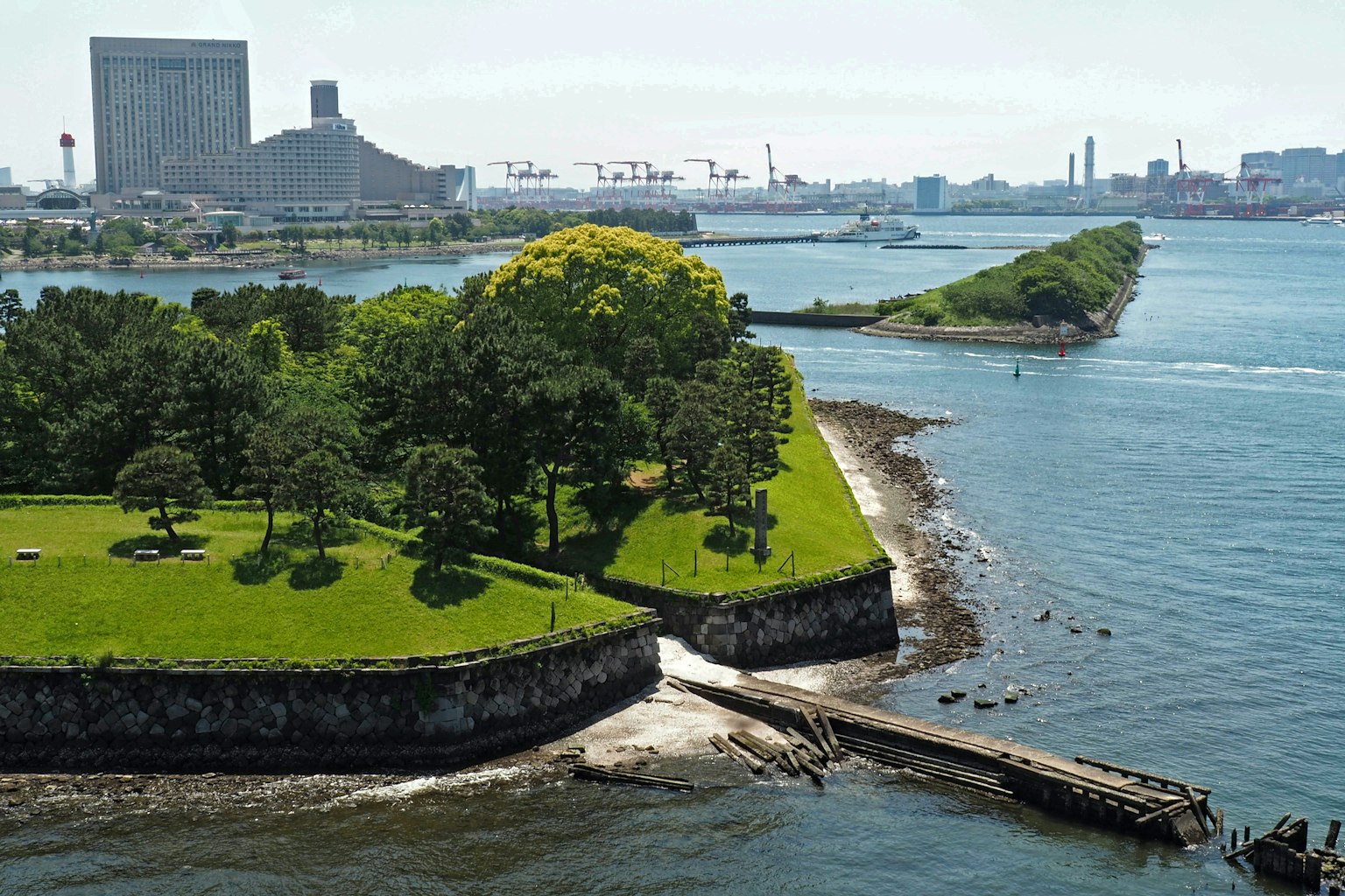 Üppiger Park mit Wasseransicht Gebäude und Hafen im Hintergrund
