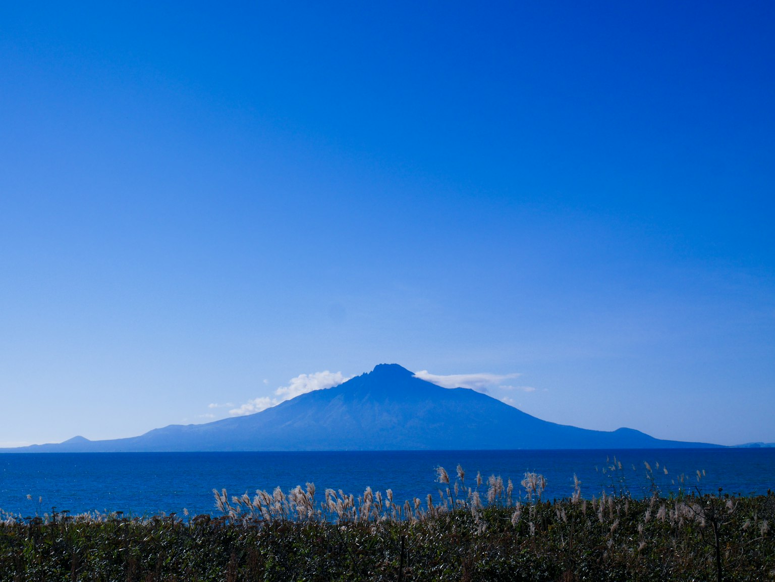 Vue panoramique d'une montagne et de la mer sous un ciel bleu clair