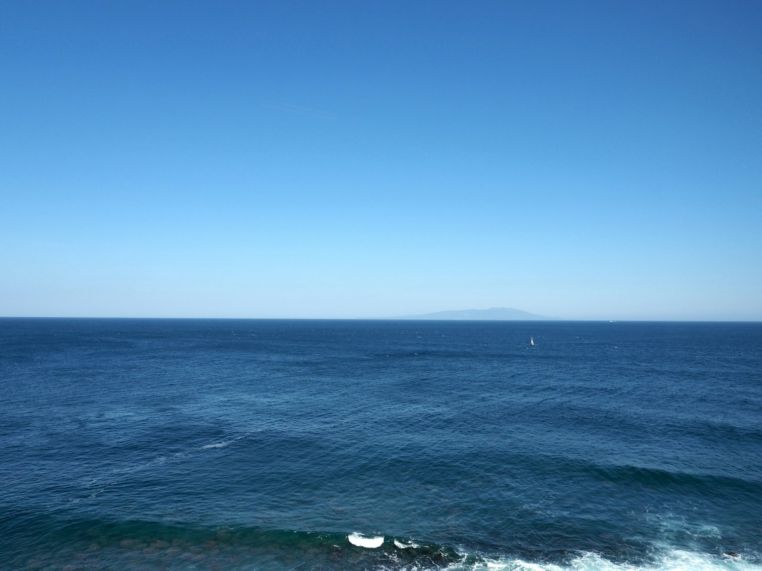Blick auf den blauen Ozean und den klaren Himmel mit Wellen