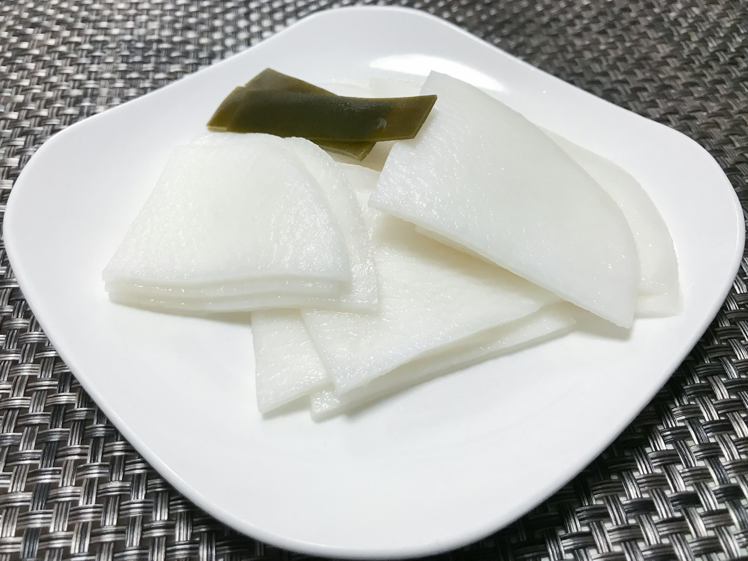 흰 무와 다시마 조각이 접시에 담겨 있다