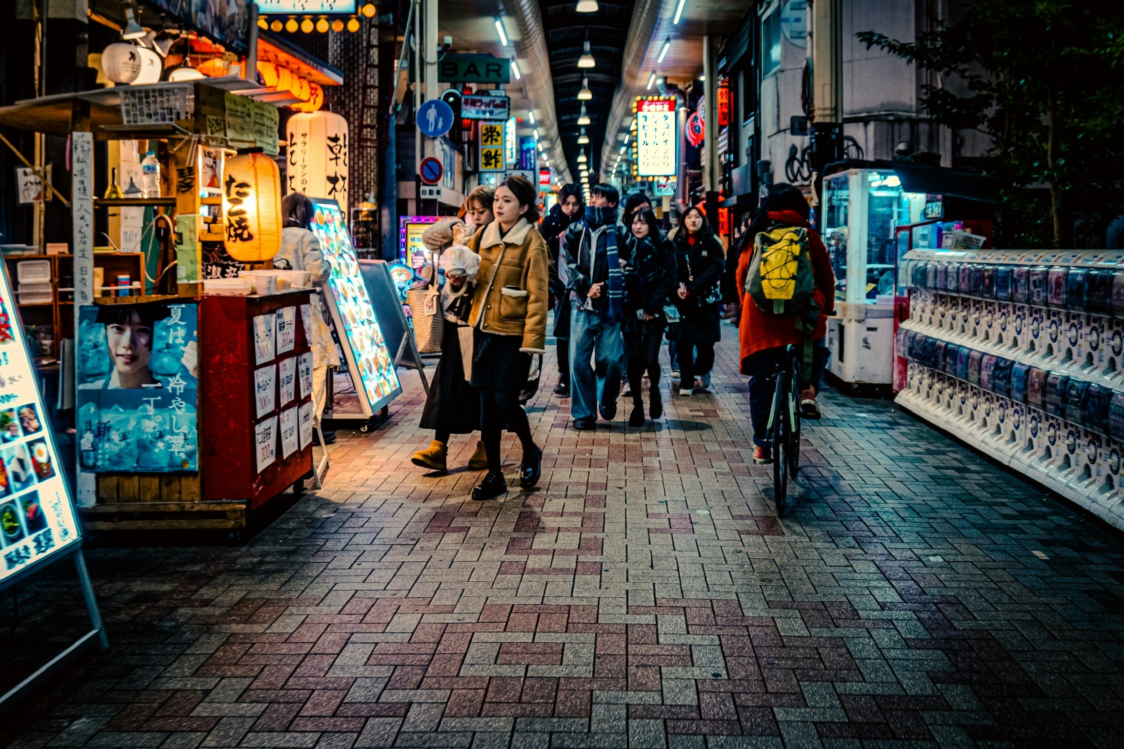 難波の夜の商店街の通りに並ぶ看板と人々の行き交い