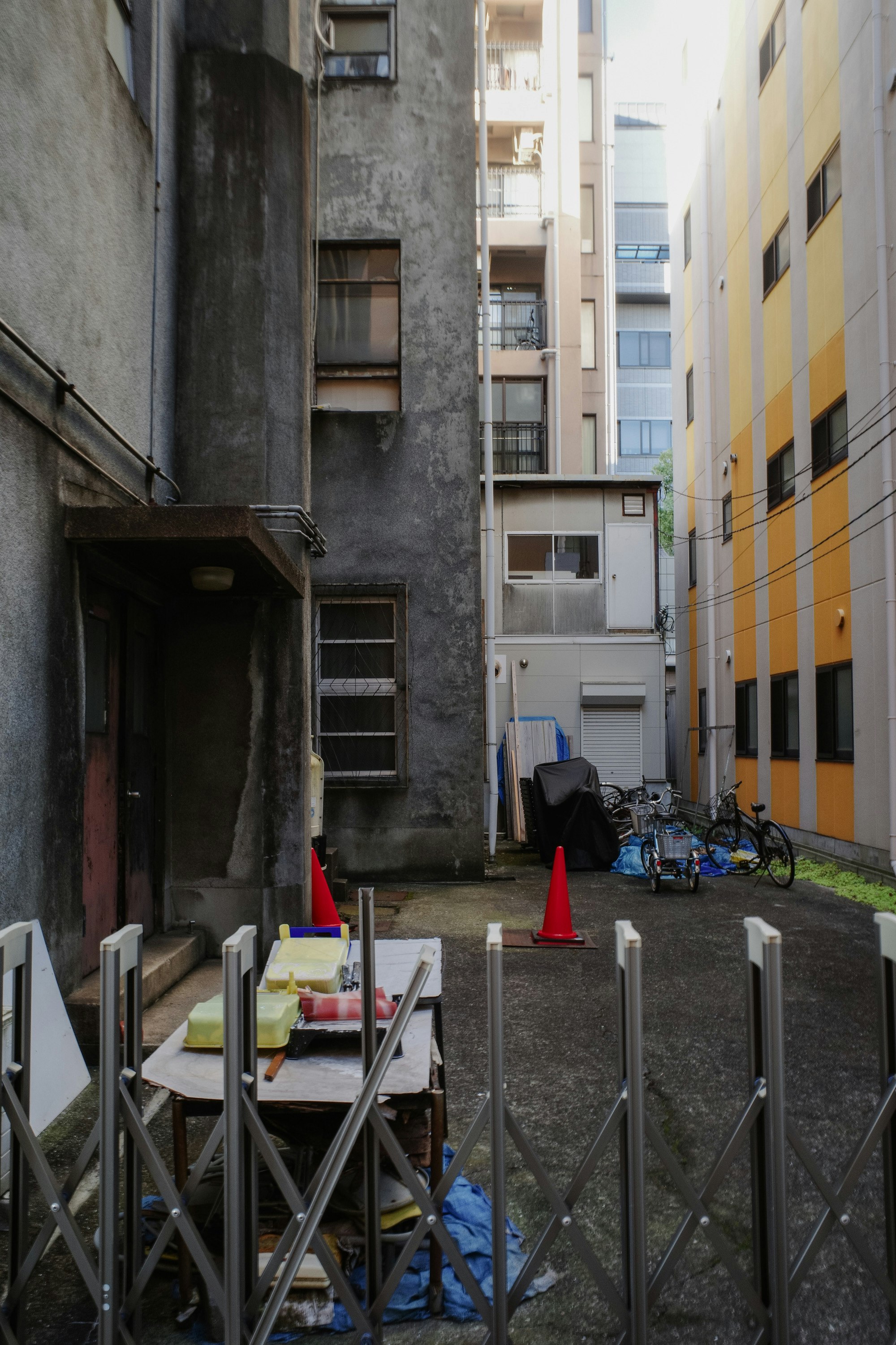 lorong sempit di antara gedung dengan sepeda dan penghalang