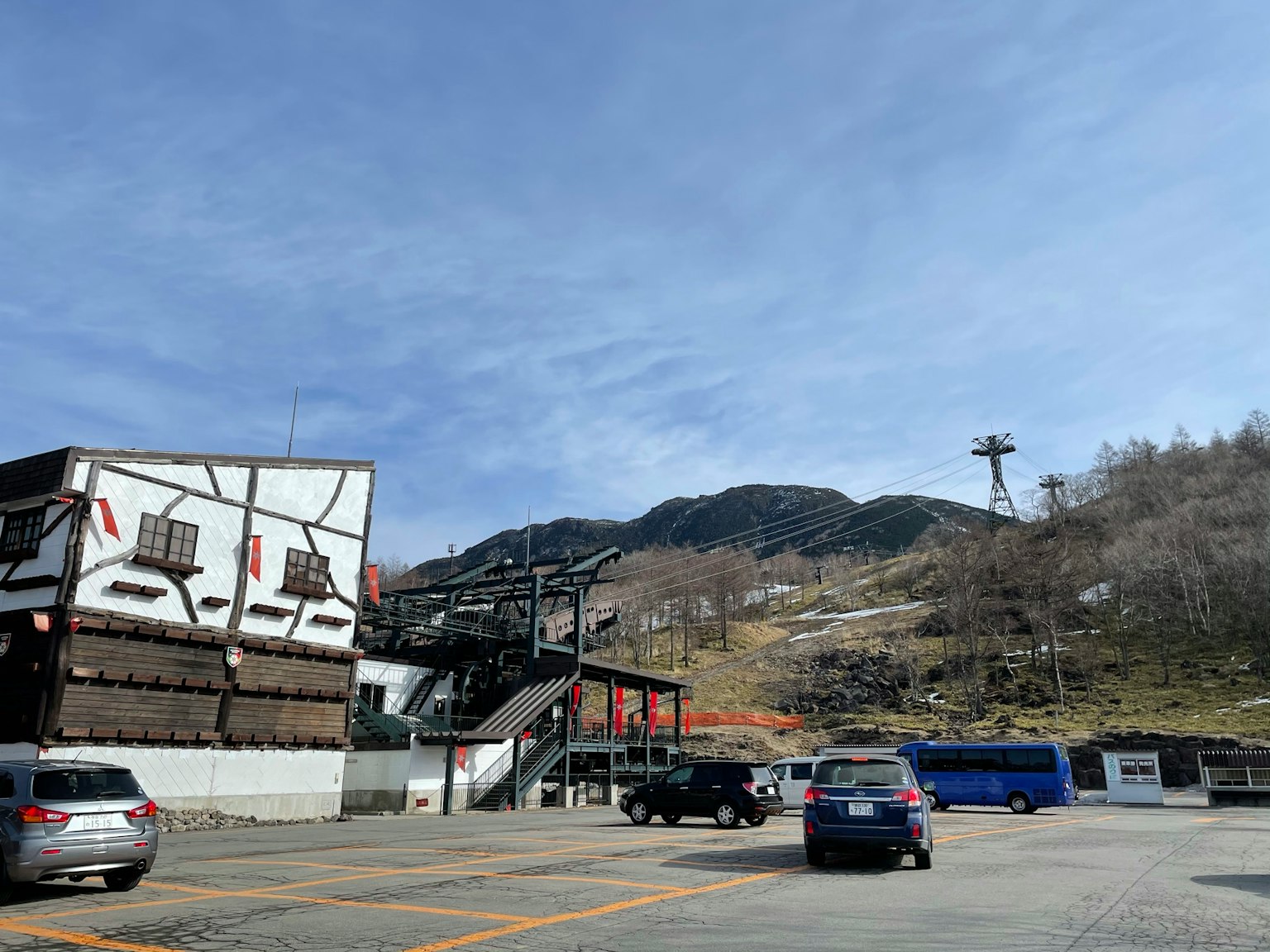 停车场景观，滑雪度假村建筑和山脉背景
