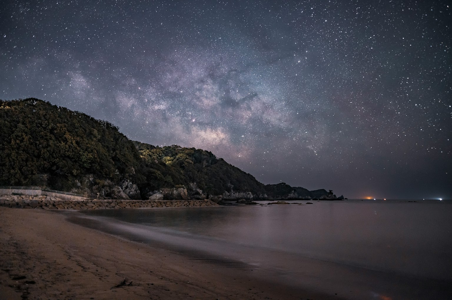 Pemandangan menakjubkan langit berbintang di atas pantai tenang