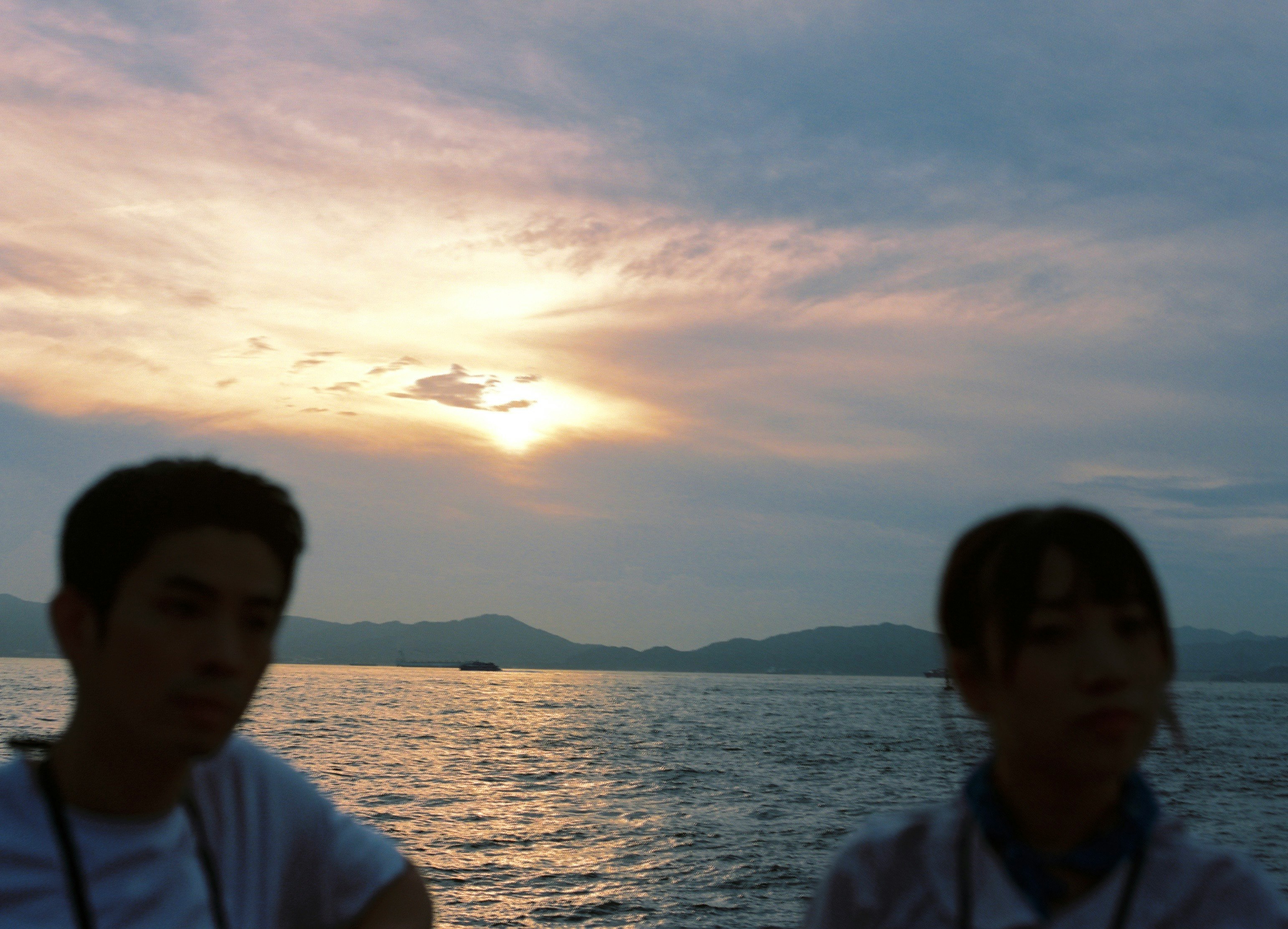 夕暮れの海辺で人物が前景にいる風景