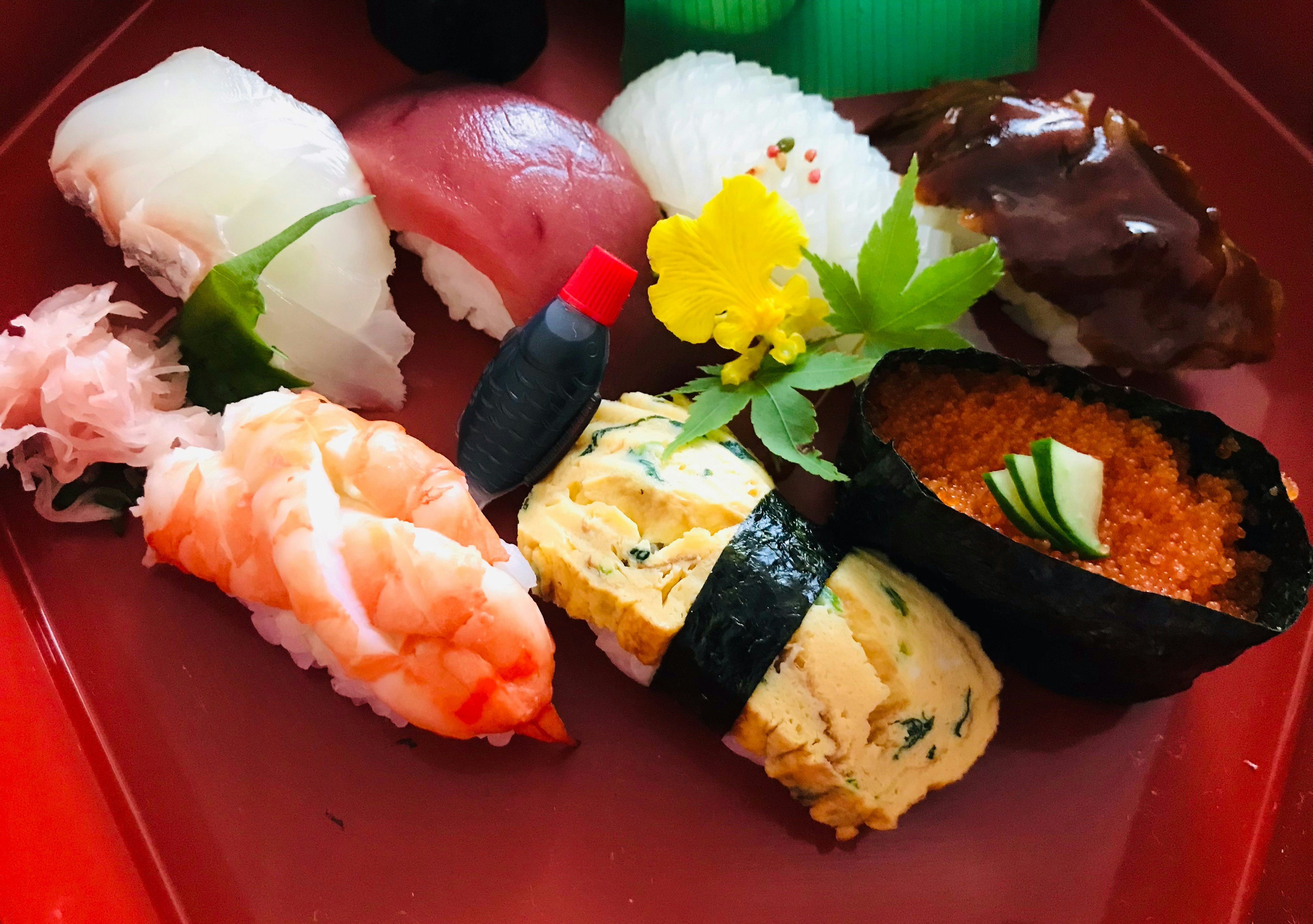 Colorful sushi arranged on a red platter