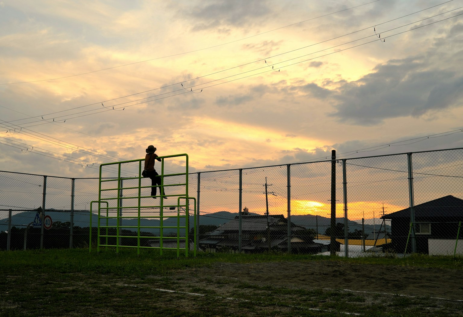 Silhouette d'un enfant grimpant sur un équipement de jeu au coucher du soleil