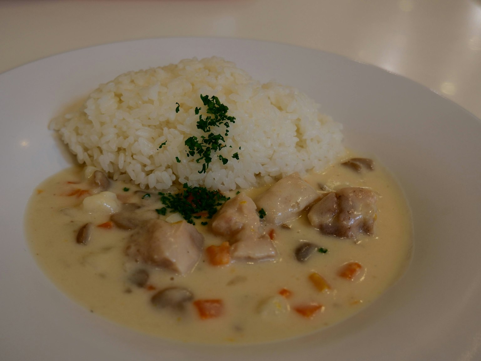 Plat de poulet crémeux avec légumes servi avec du riz blanc moelleux