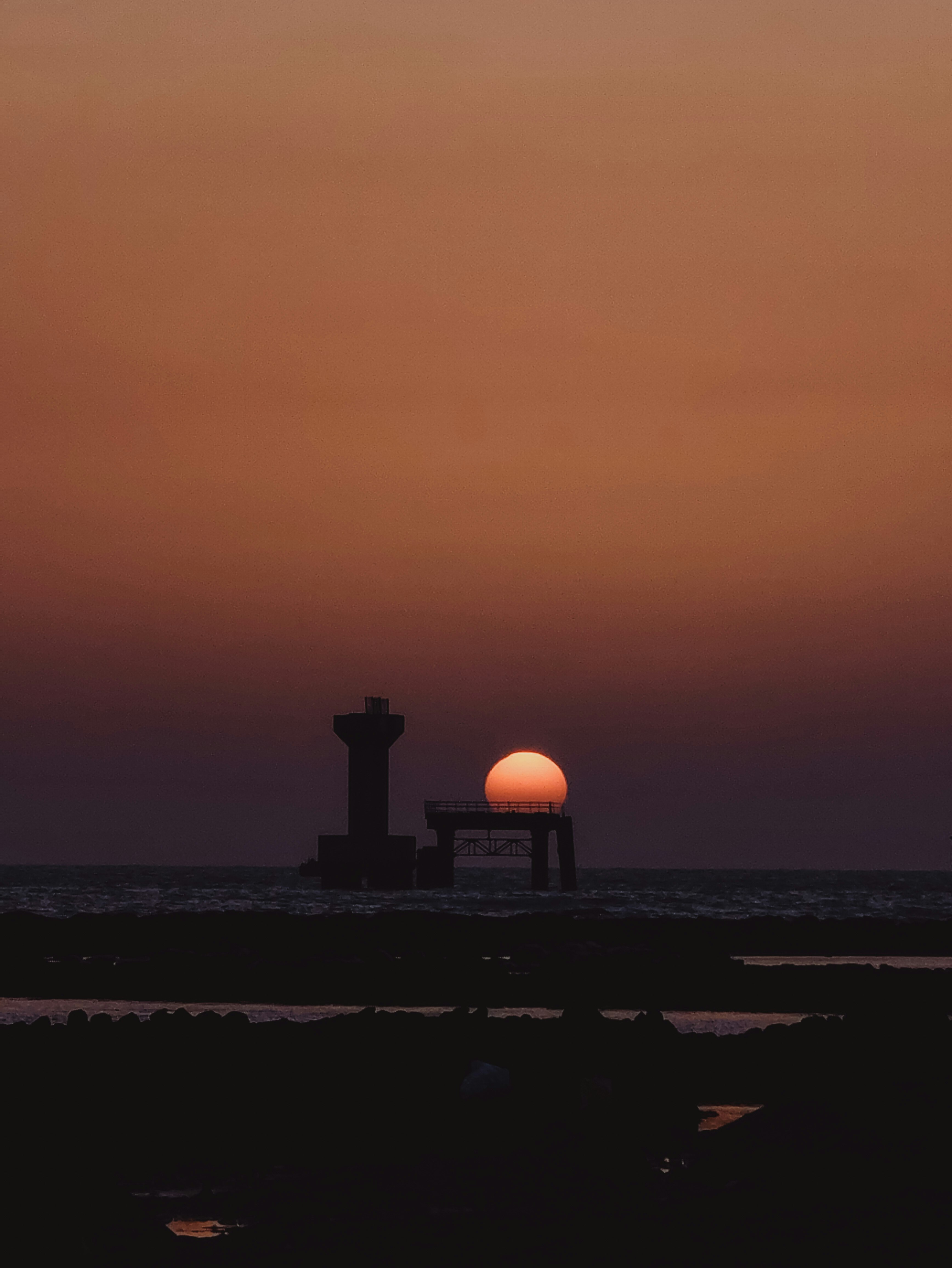 夕日が沈む海岸のシルエットと美しいグラデーションの空