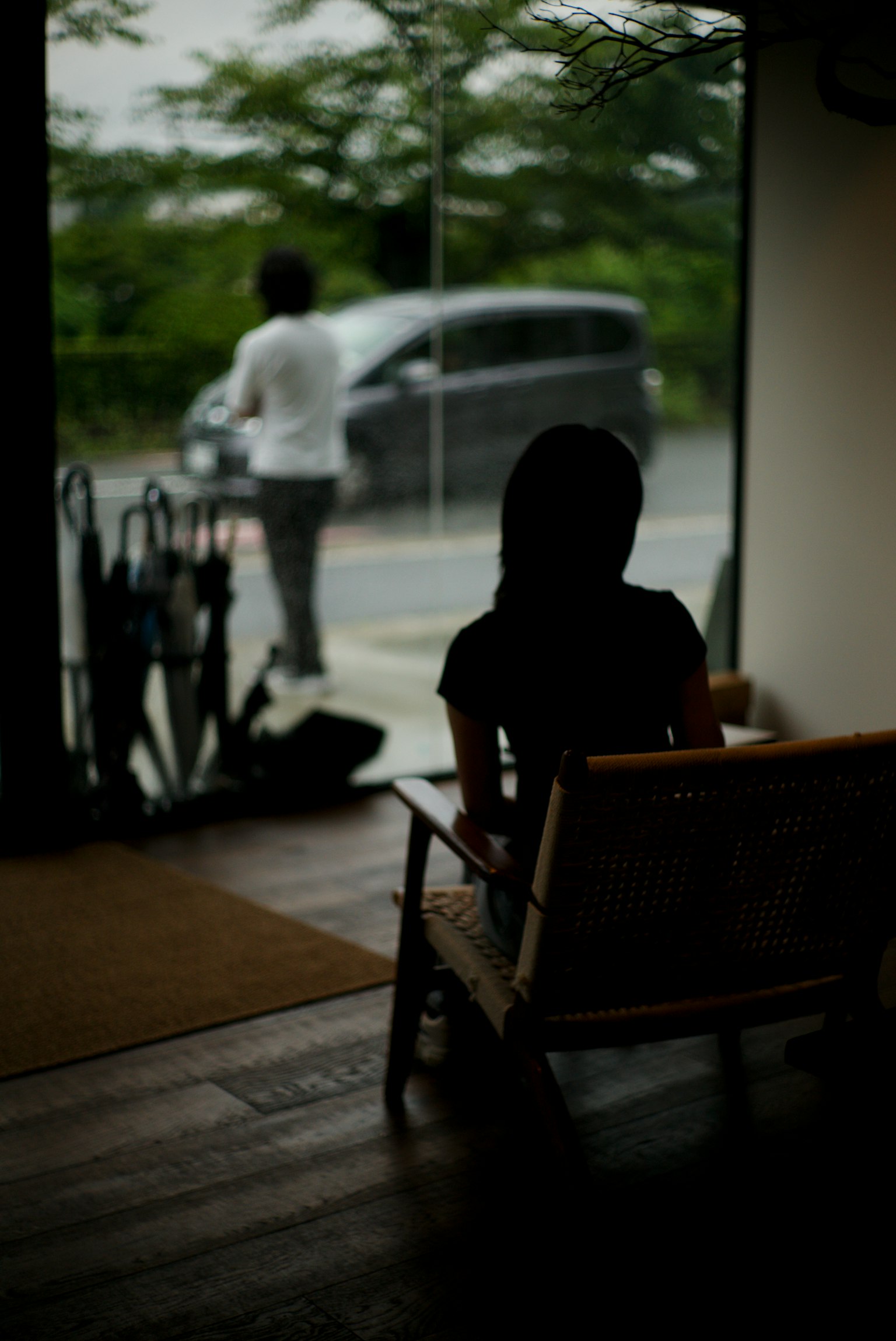 坐在室內看向窗外的女性輪廓和外面的男性