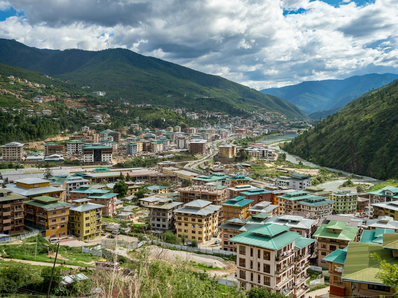 Vue pittoresque d'une ville vallonnée avec des bâtiments à toit vert
