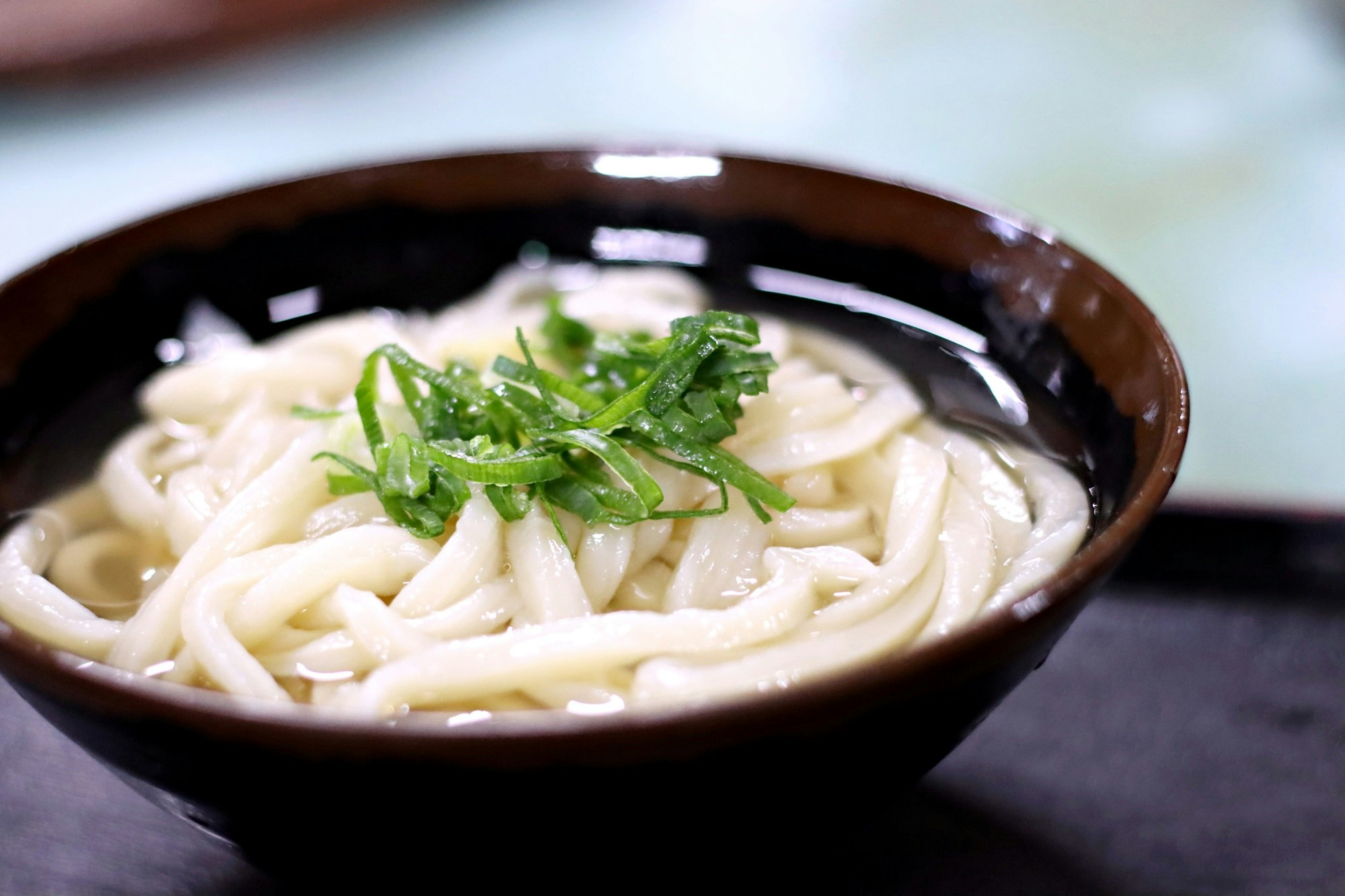 碗裝烏龍麵，上面鋪蔥花