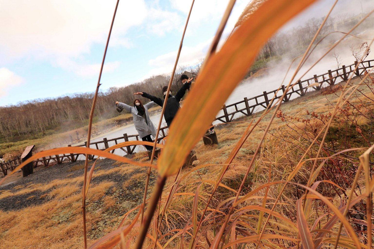 Two people enjoying the scenery near a hot spring with steam