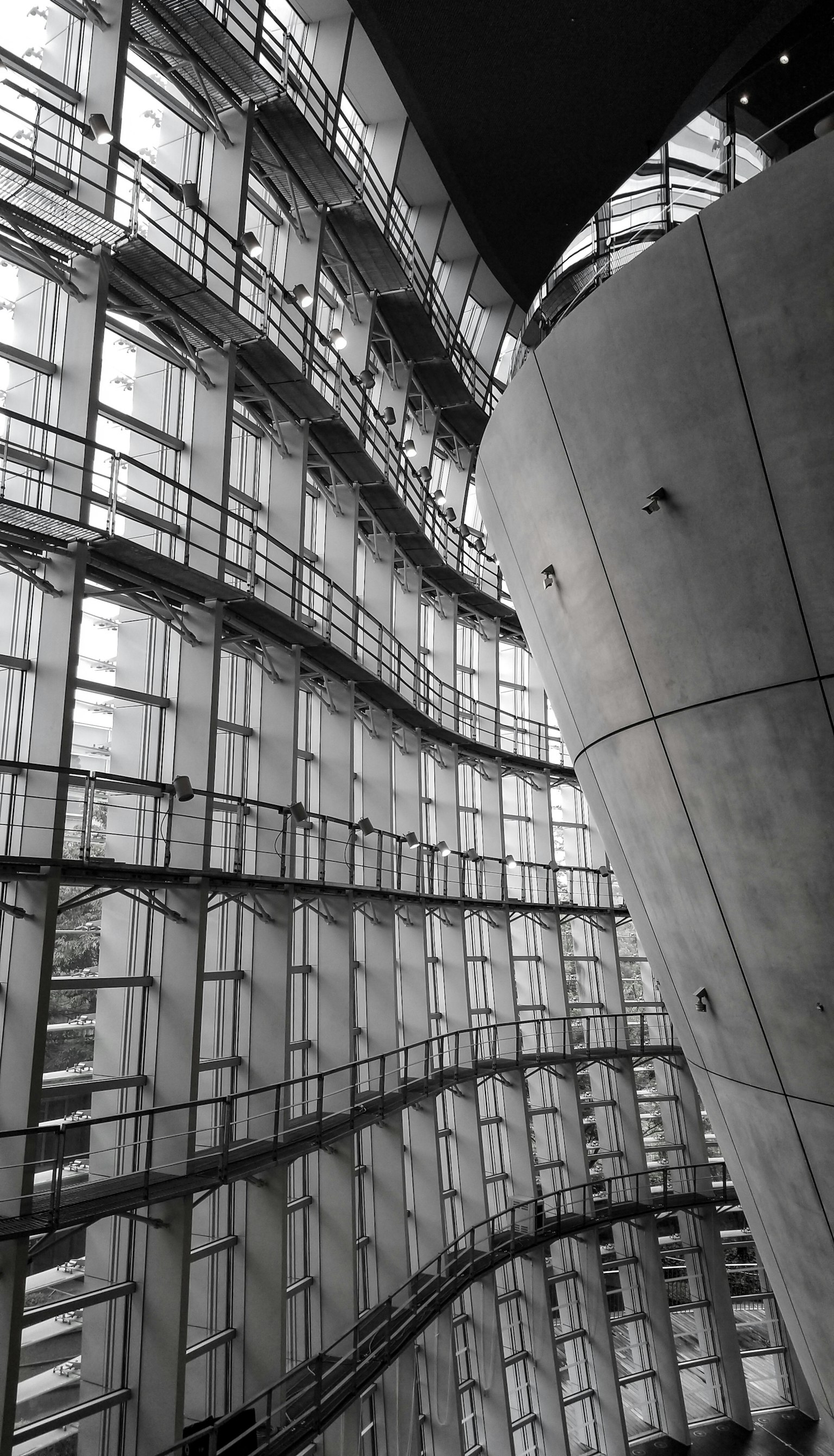 Innere Struktur eines modernen architektonischen Designs Kurven und gerade Linien kreuzen sich in einer Glas- und Betontfassade