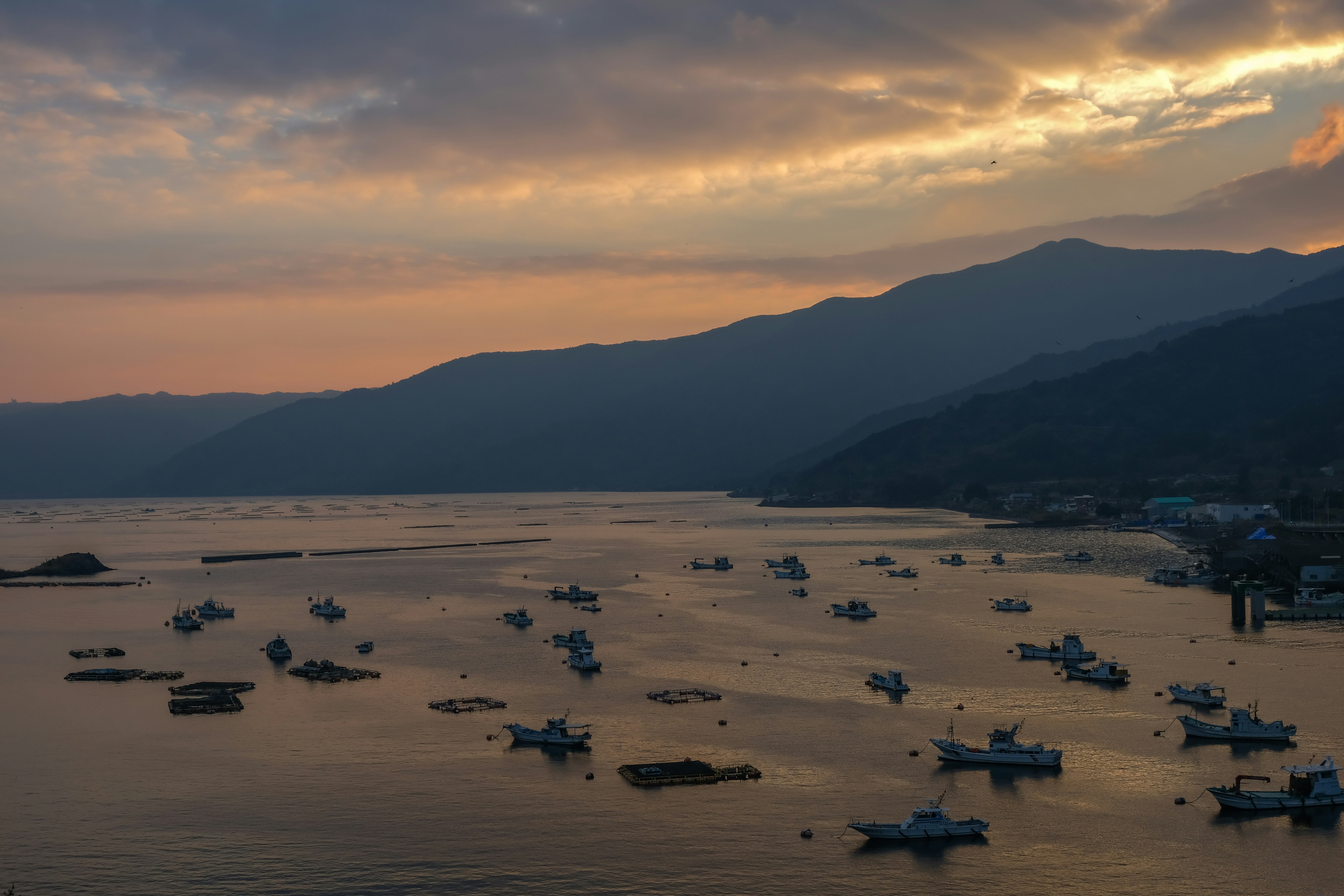 早朝の牛根大橋と桜島を望む港の船だまり